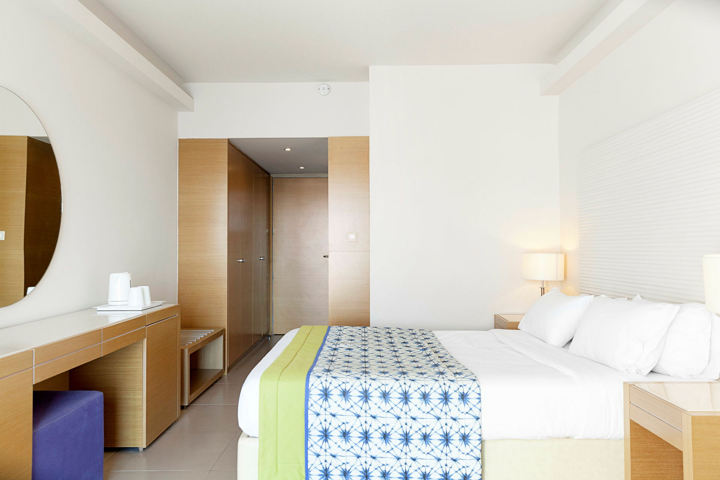 Et moderne hotellrom med en romslig seng og minimalistisk innredning. (AI-generert tekst)