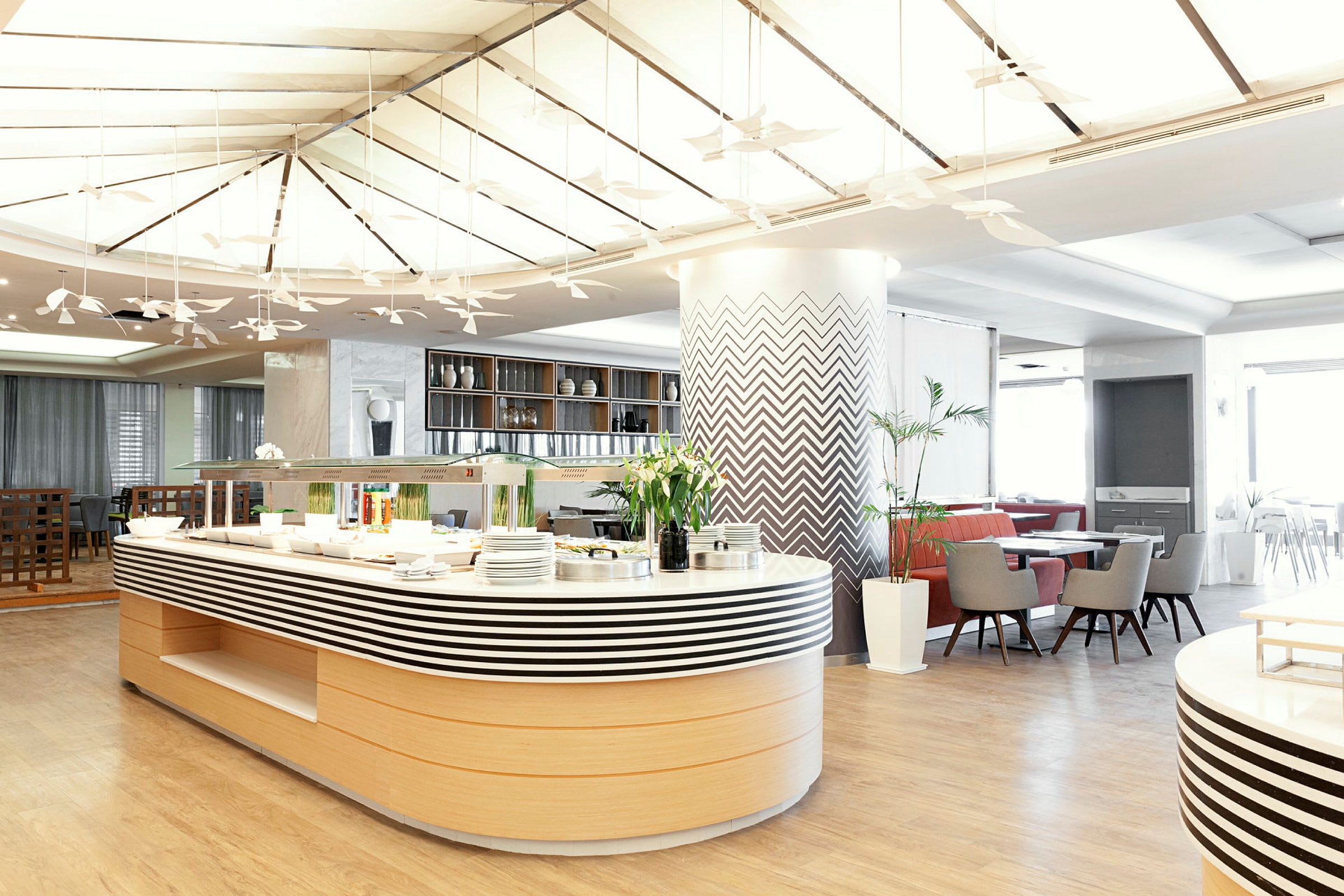 Moderne restaurant med buffetbord og sitteplasser. (AI-generert tekst)