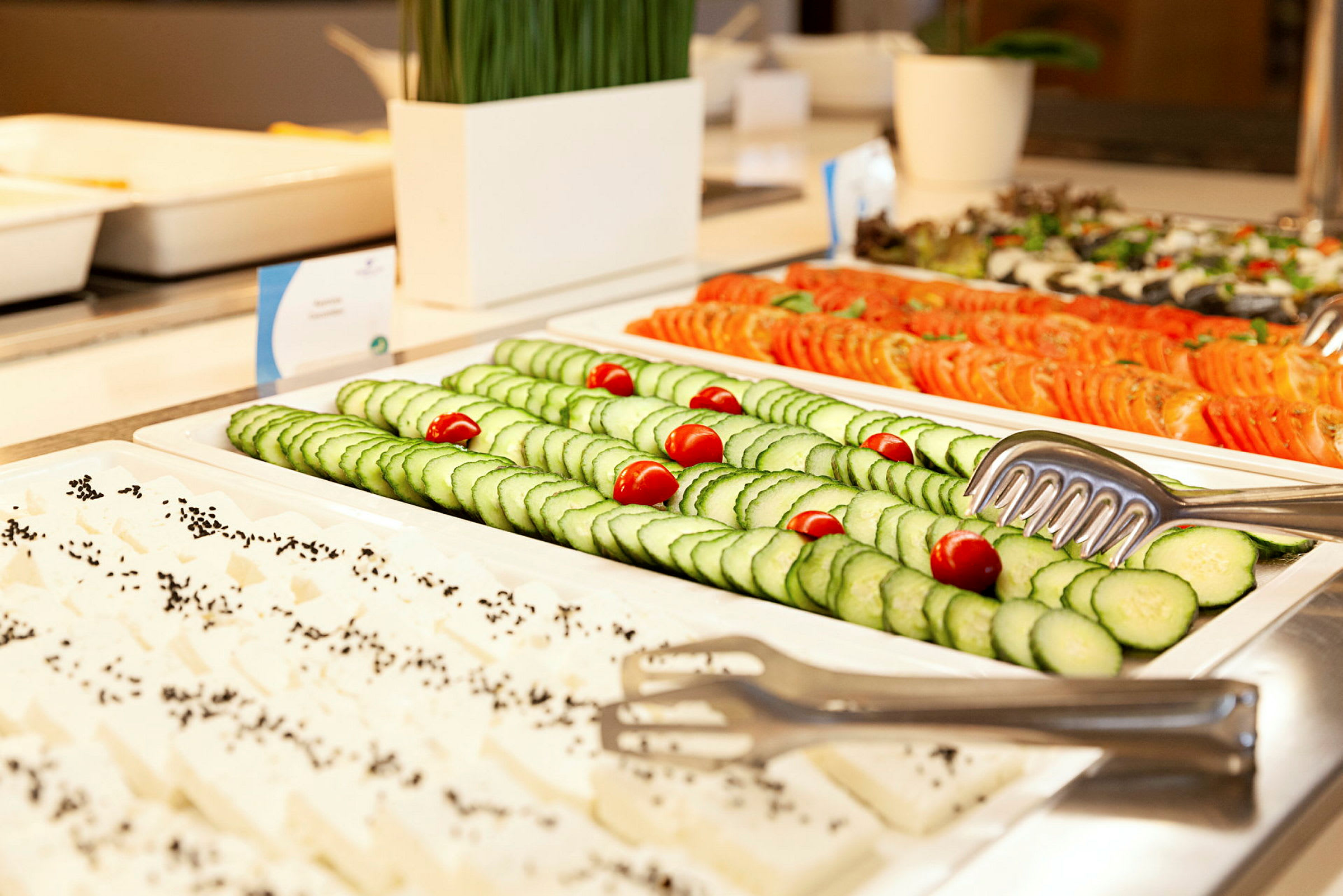 Buffet med oppskårne skiver av agurk, tomat og fetaost. (AI-generert tekst)