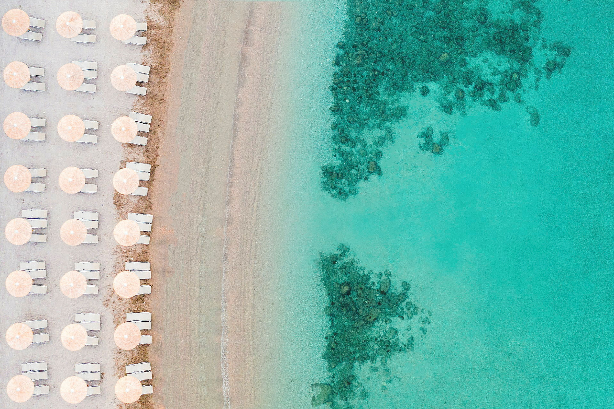 Strand med parasoller og solsenger på en rad ved kanten av turkis vann. (AI-generert tekst)