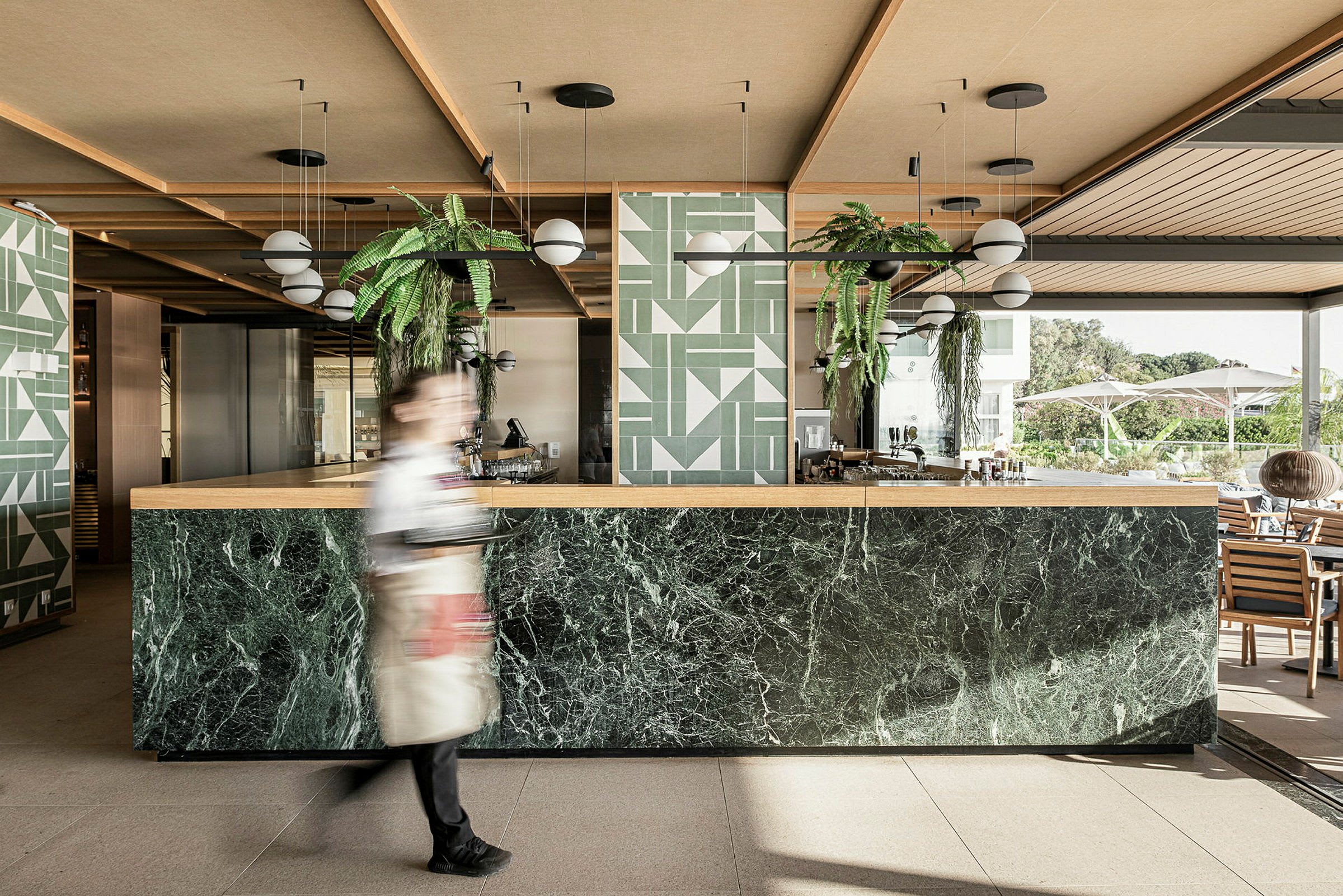 En moderne hotellbar med marmordisken og grønne planteinnslag. (AI-generert tekst)