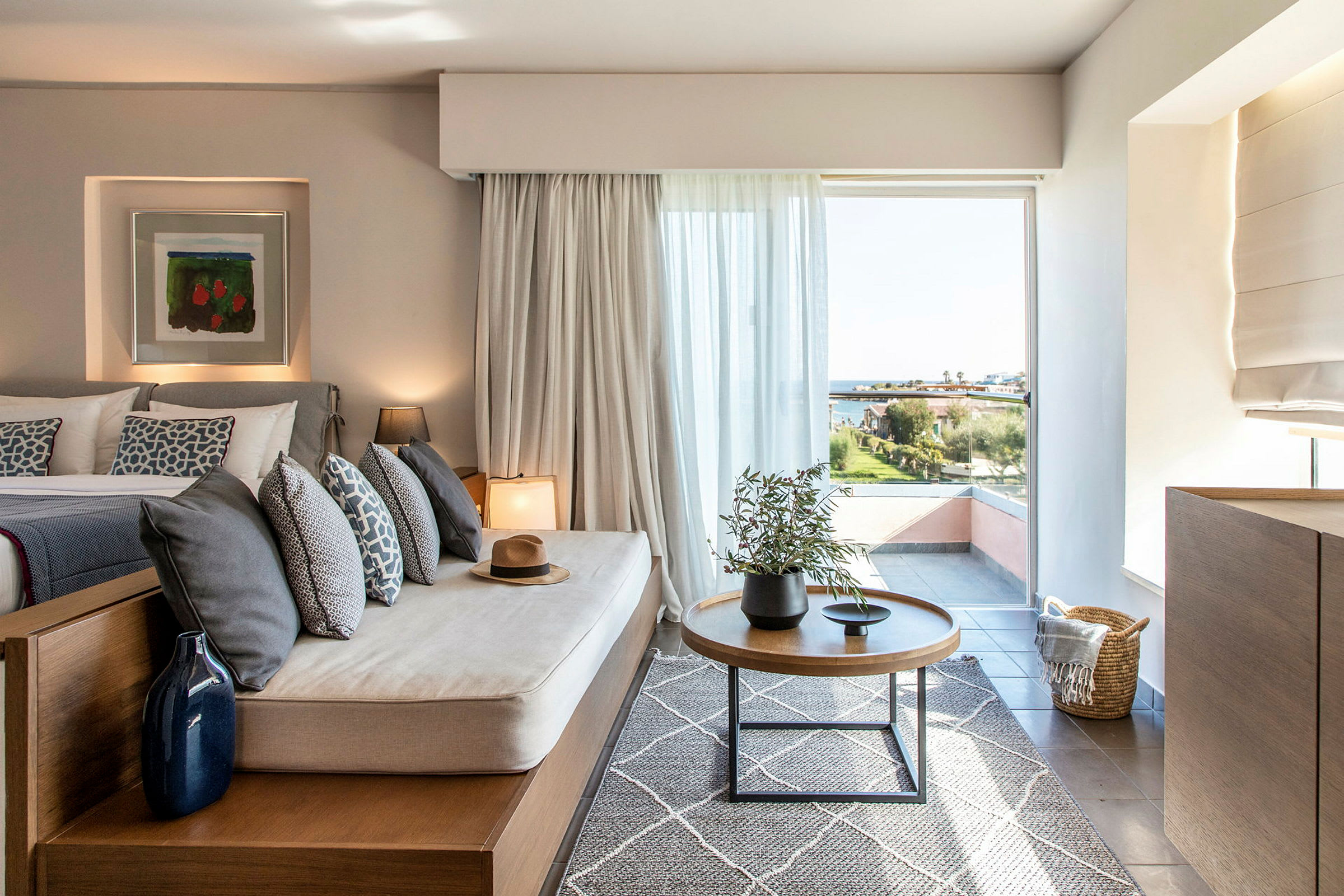 Bilde av et moderne hotellrom med en sittemøbel og utsikt over landskapet gjennom et stort vindu. (AI-generert tekst)