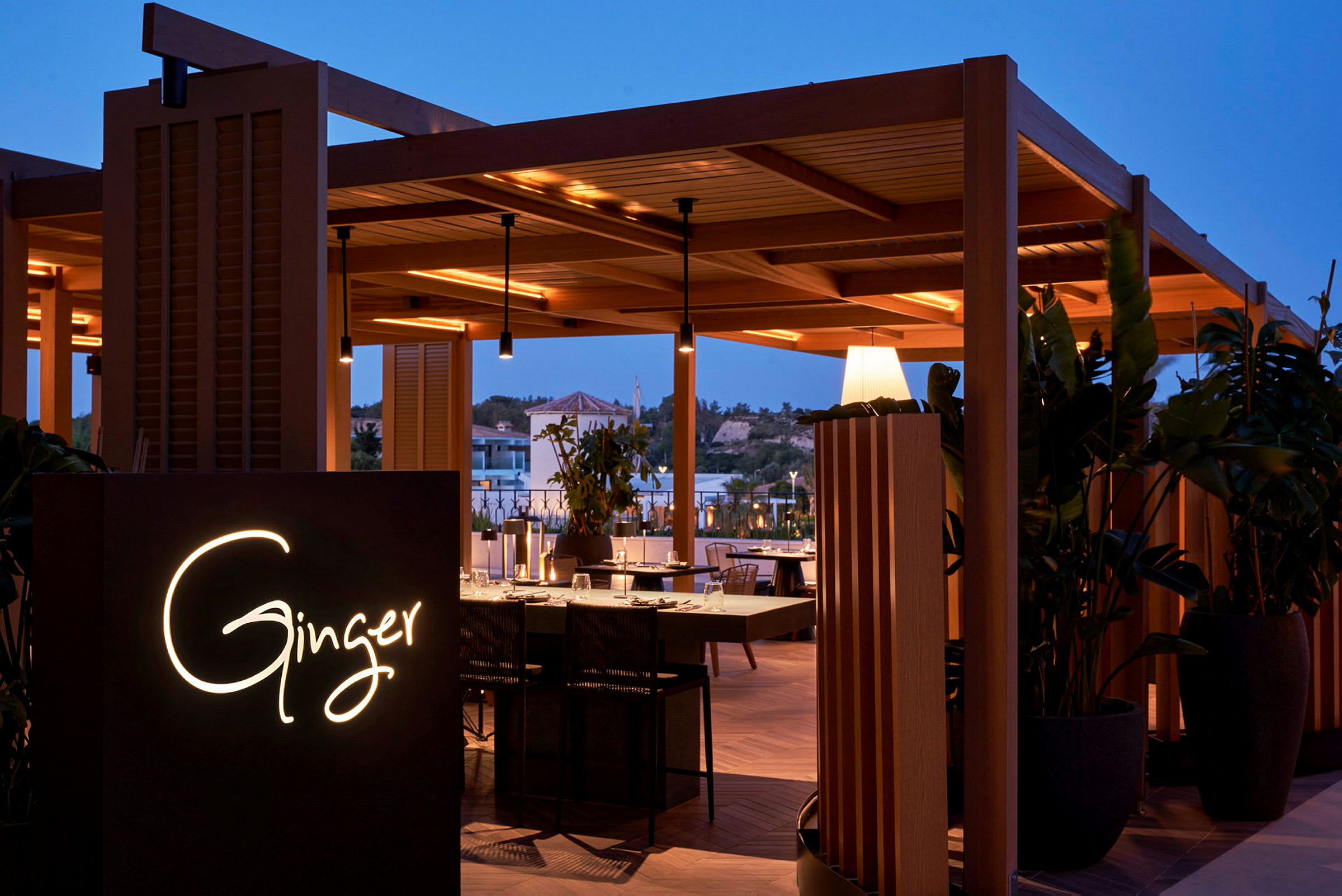 Restauranten Ginger med trematerial under dempet belysning, omgitt av planter. (AI-generert tekst)