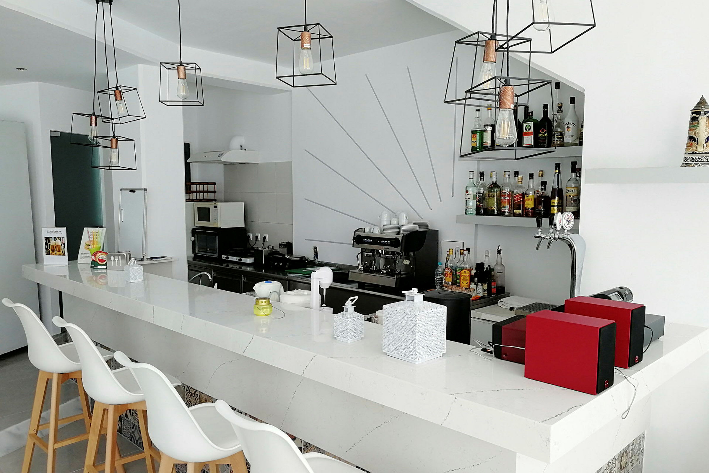 En moderne bar med minimalistisk design og flere flasker alkohol på hyllen. (AI-generert tekst)