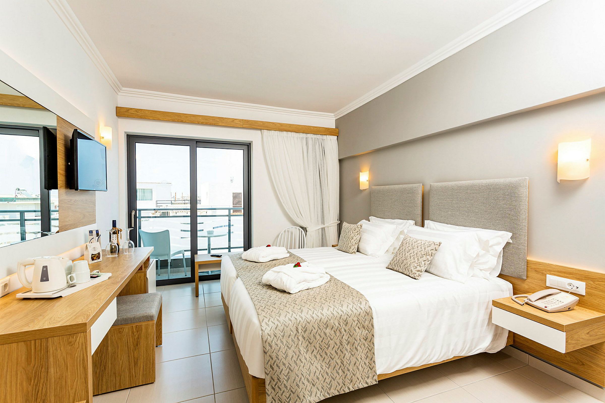 Moderne hotellrom med dobbeltseng, skrivebord og balkong. (AI-generert tekst)