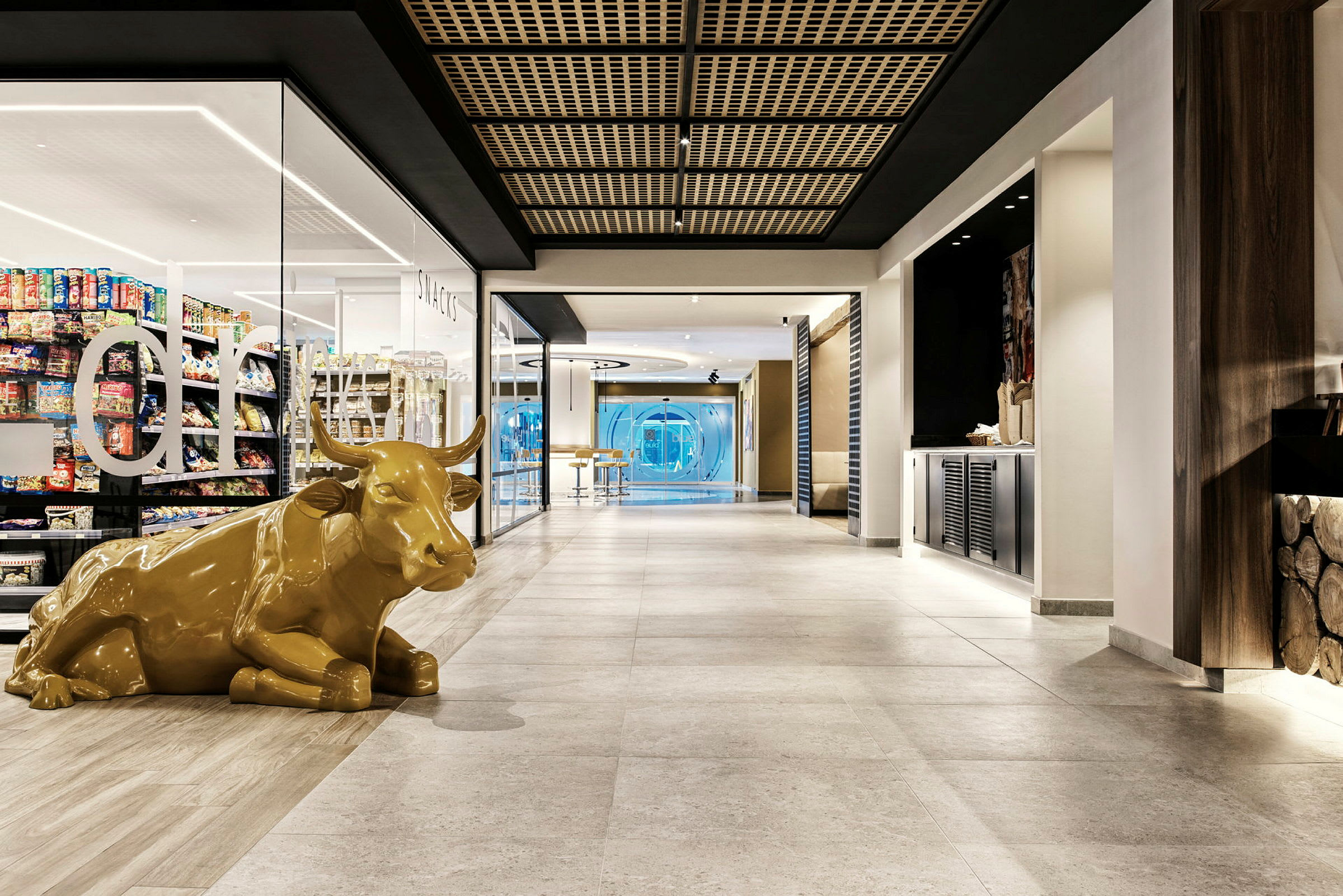 Interiør av en moderne hall med en gul skulptur av en ku. (AI-generert tekst)