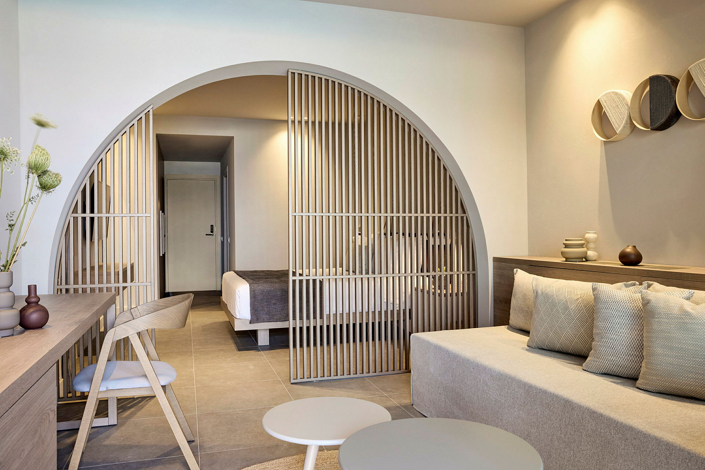 Moderne hotellrom med sittegruppe og avskjerming mot soveområde. (AI-generert tekst)
