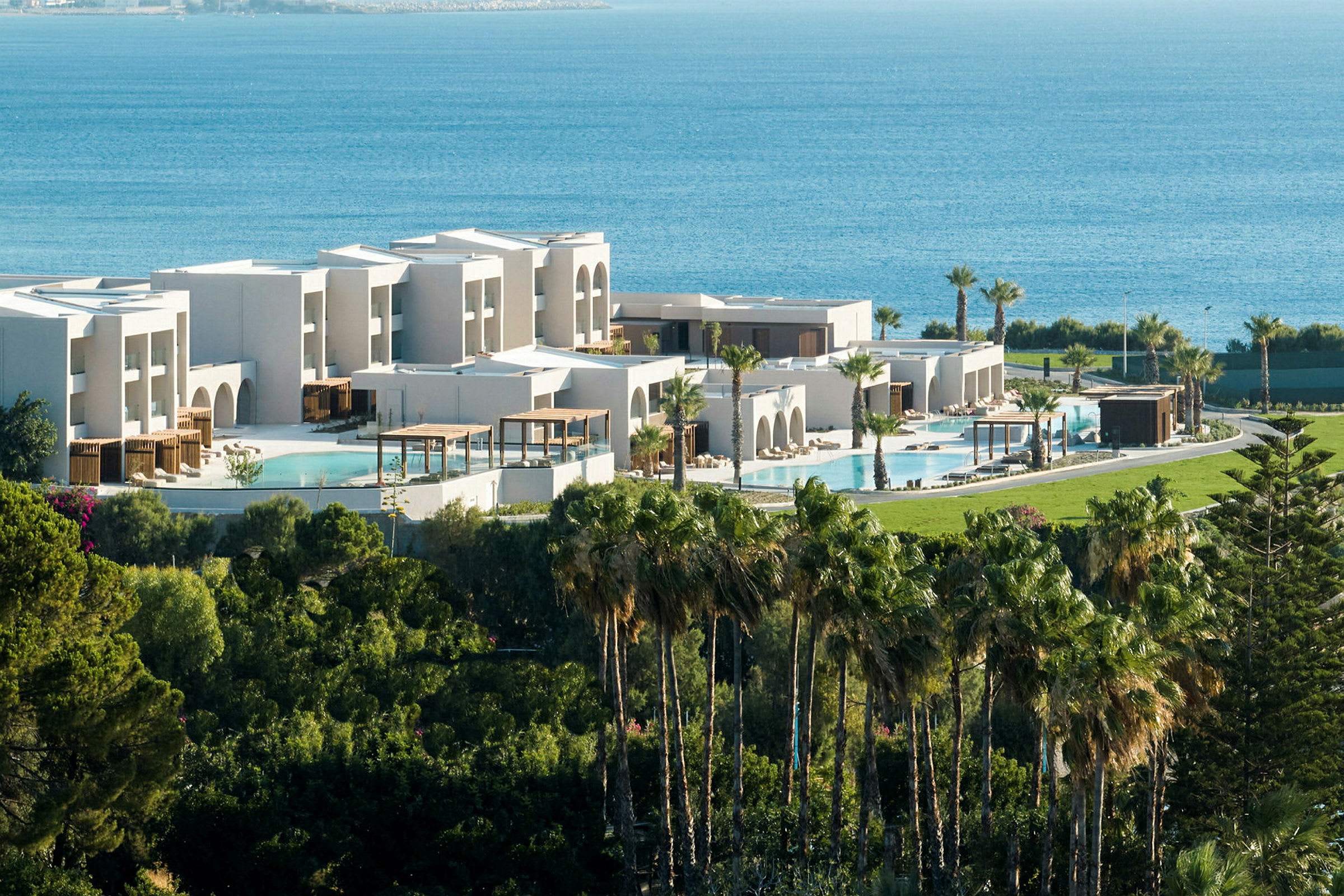 Moderne resort med bassenger, grøntområder og havet i bakgrunnen. (AI-generert tekst)