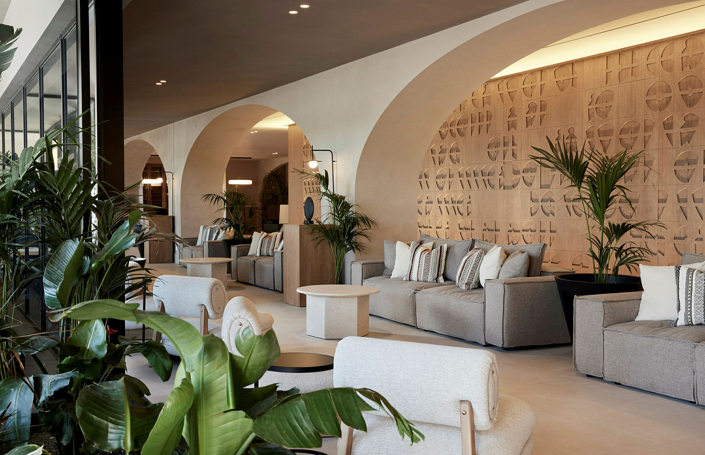 Moderne hotellounge med arkitektoniske buer og komfortable sitteplasser. (AI-generert tekst)
