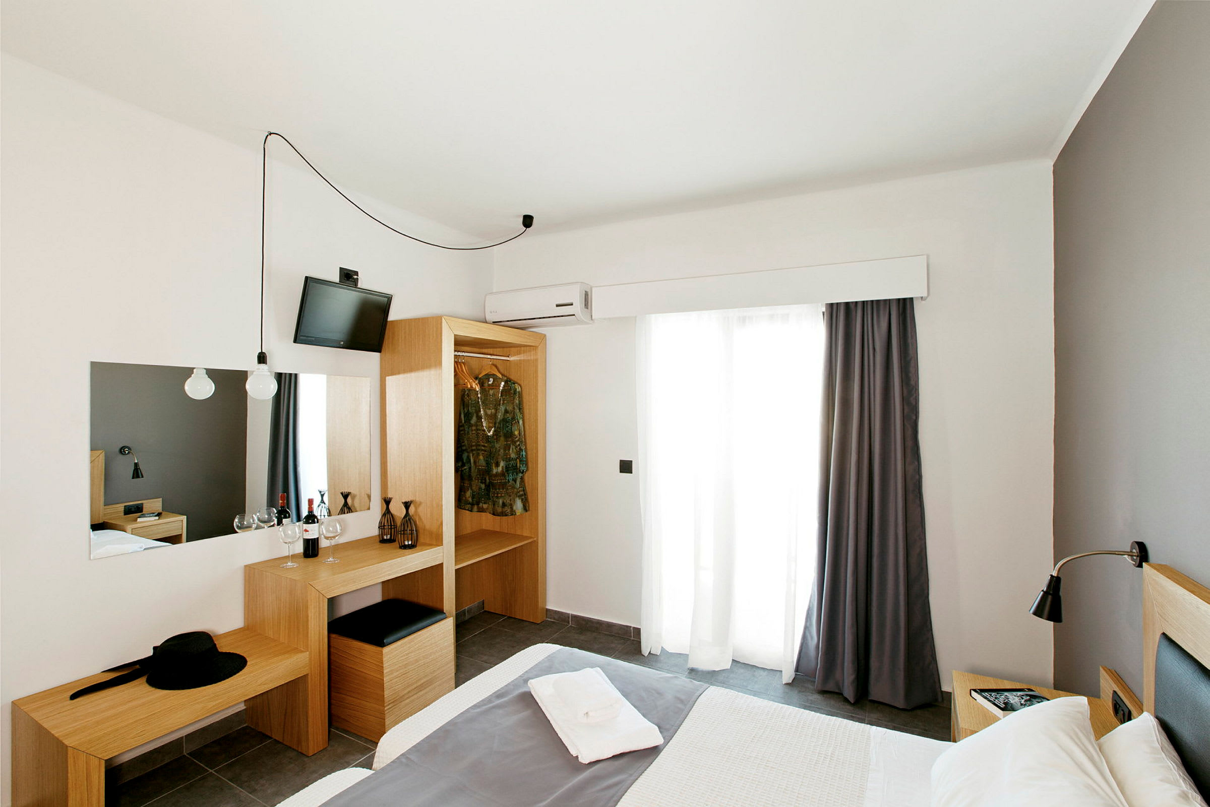 Et hotellrom med en seng, garderobe og et skrivebord. (AI-generert tekst)