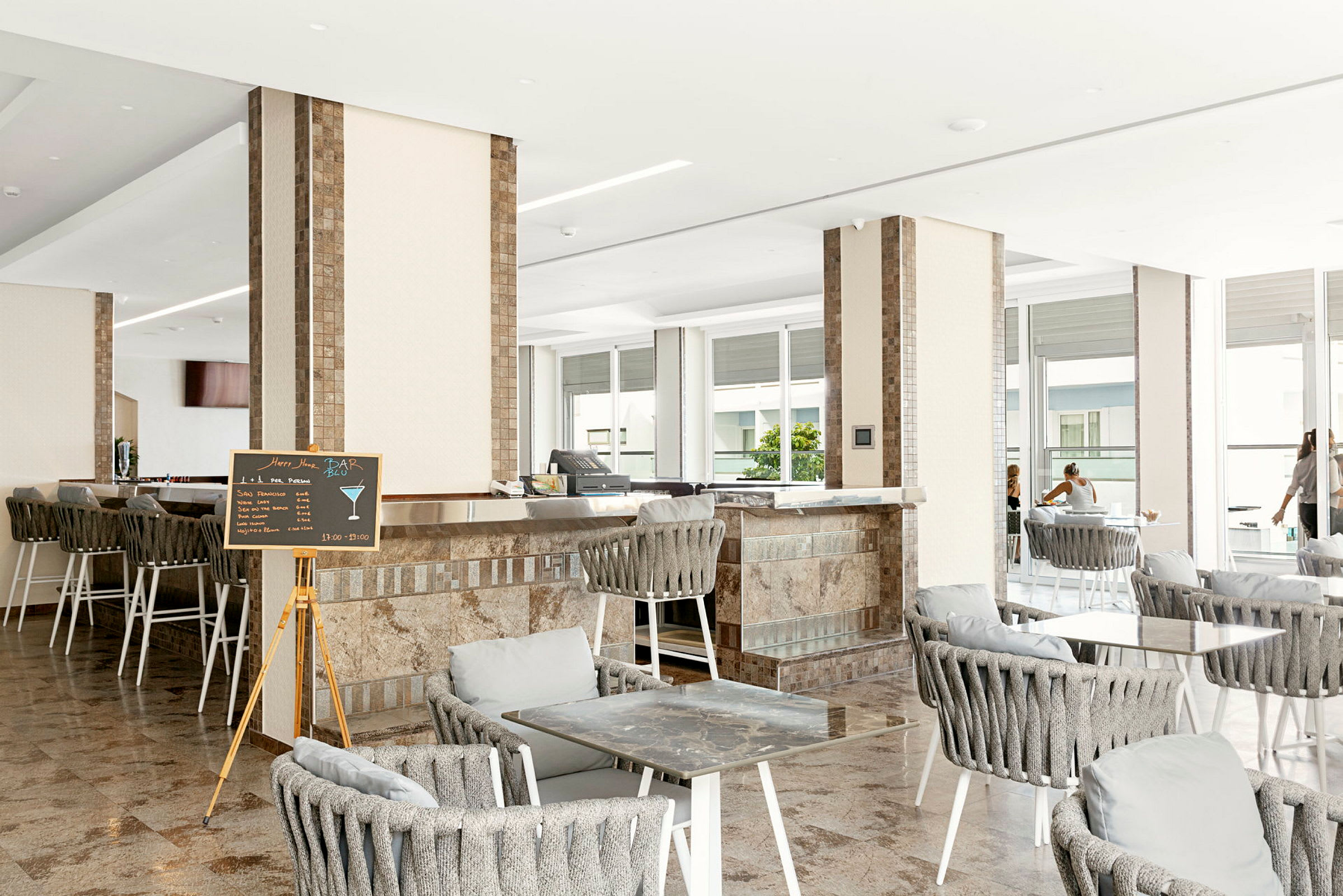 Interiør av en bar/lounge med sitteplasser og bord. (AI-generert tekst)