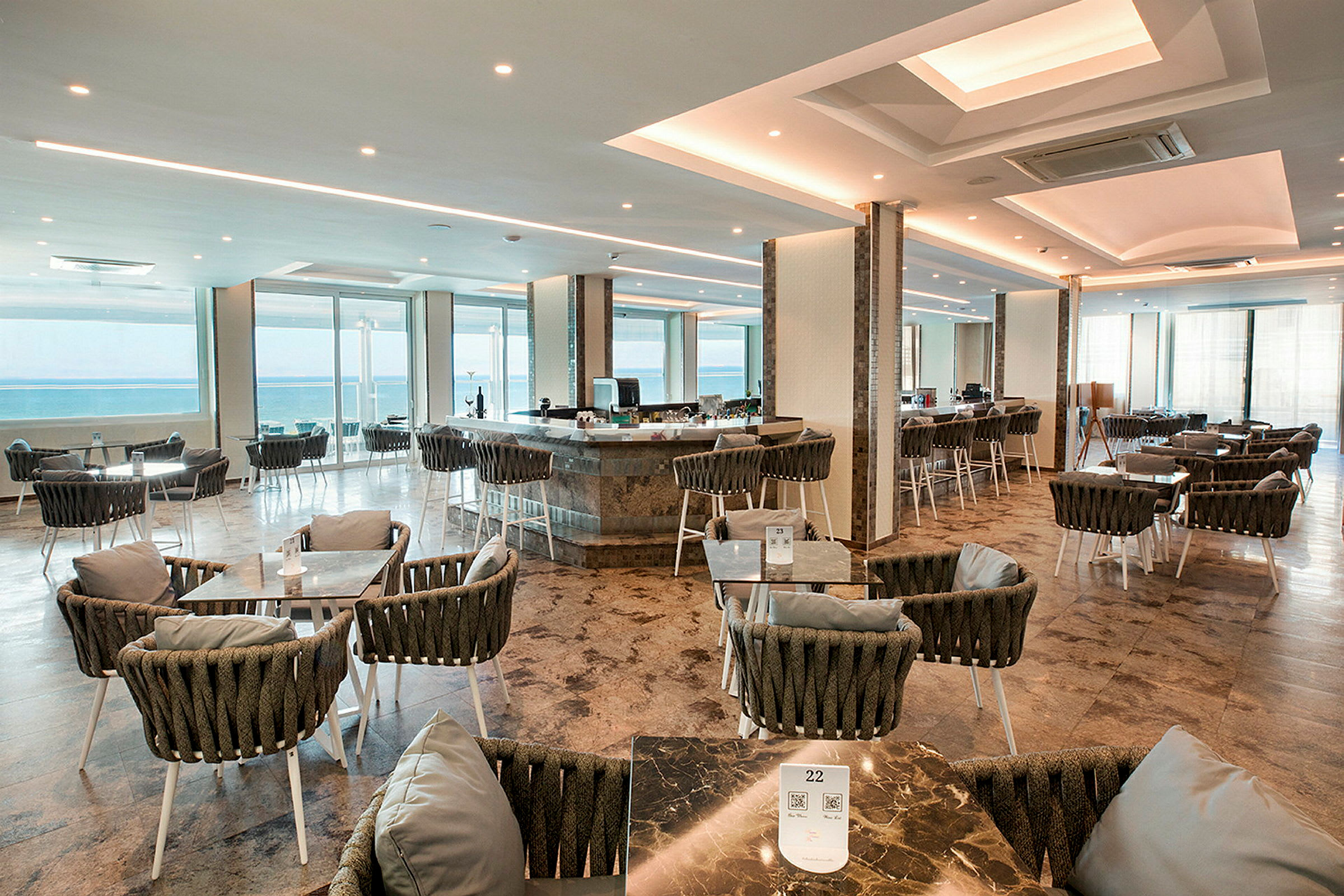 En romslig restaurant med sitteplasser og utsikt over havet. (AI-generert tekst)