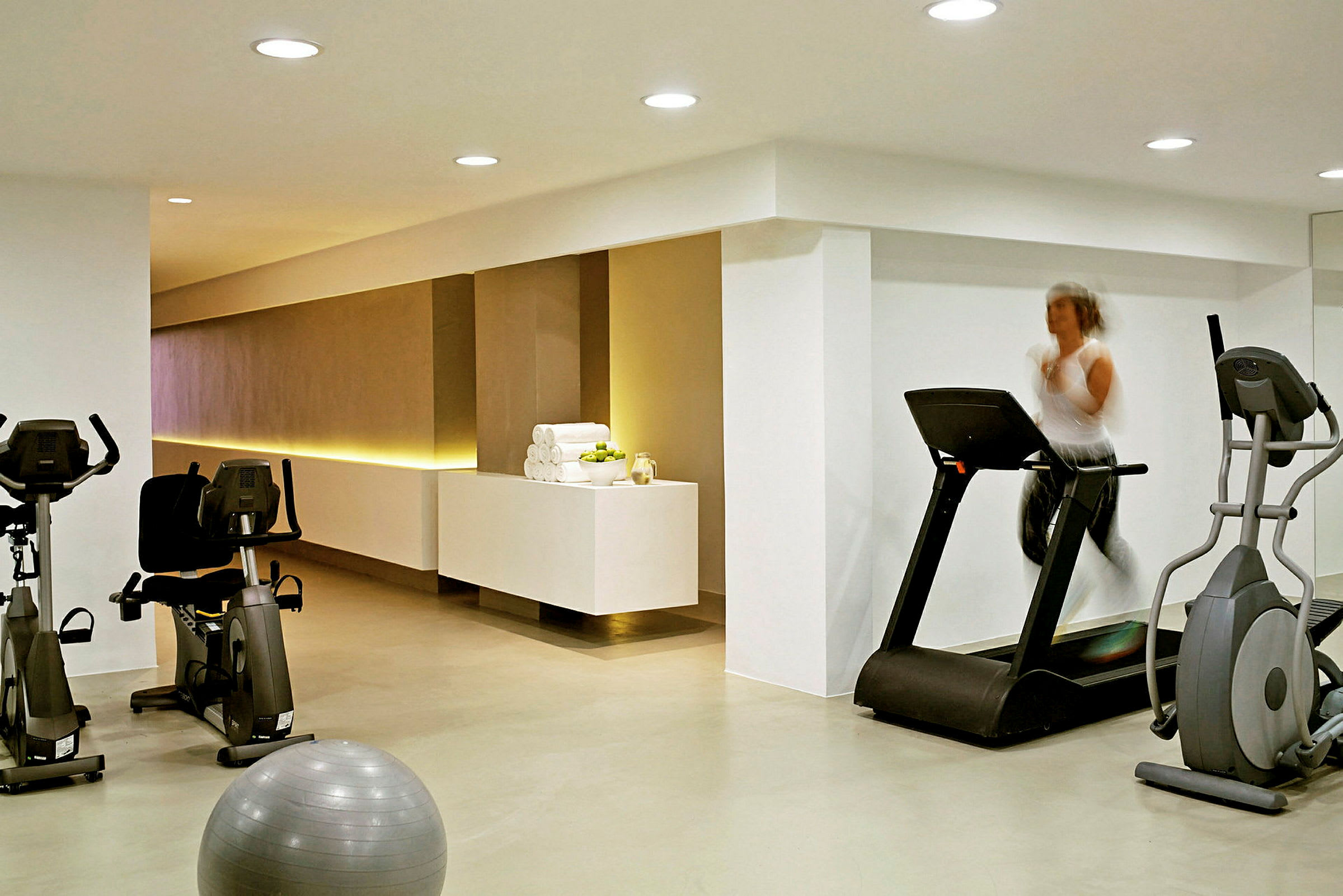 Et treningsrom med treningsmaskiner og en pilatesball. (AI-generert tekst)