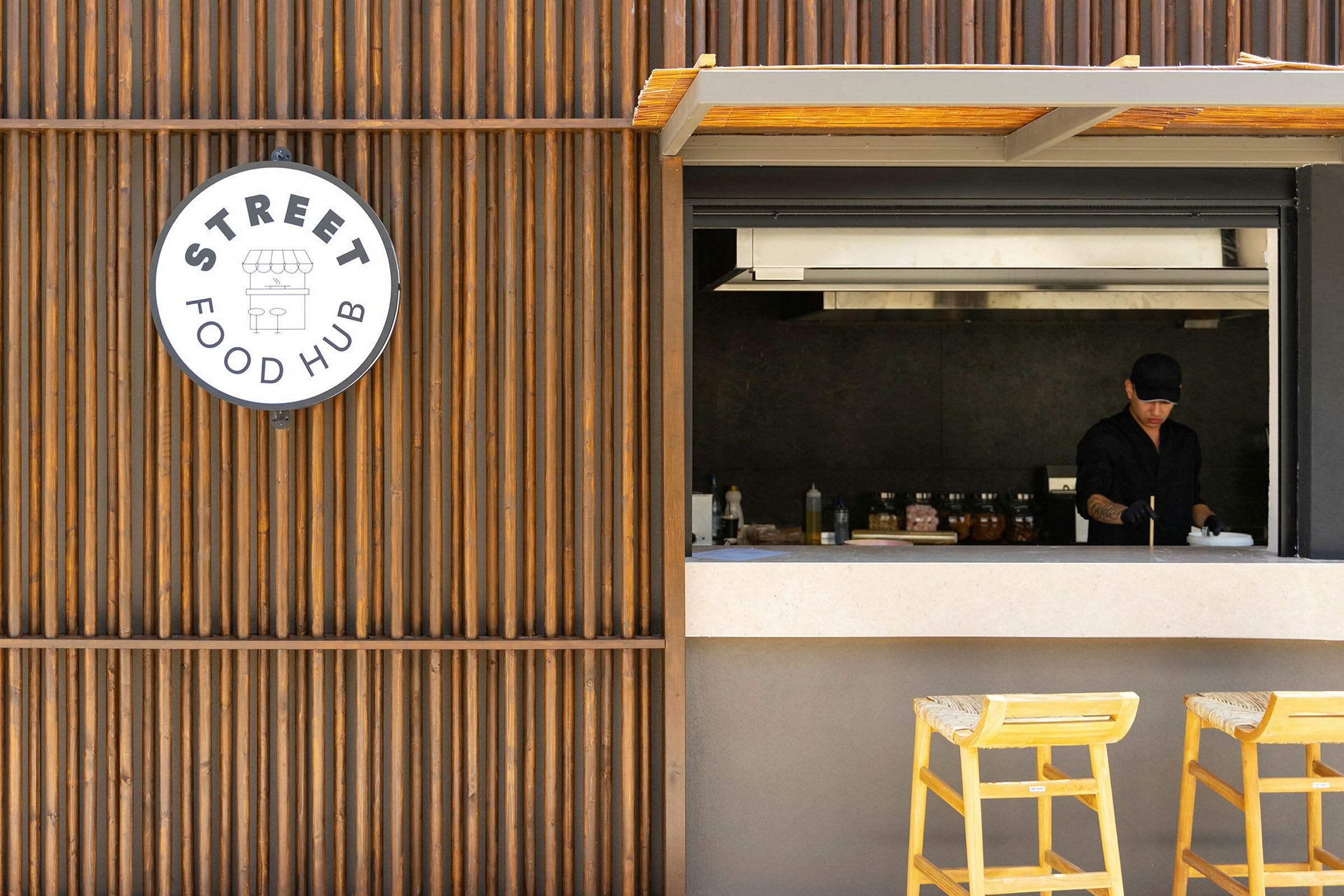 Utsikt mot en matservering med en åpen serveringsluke og et skilt som viser 'Street Food Hub'. (AI-generert tekst)