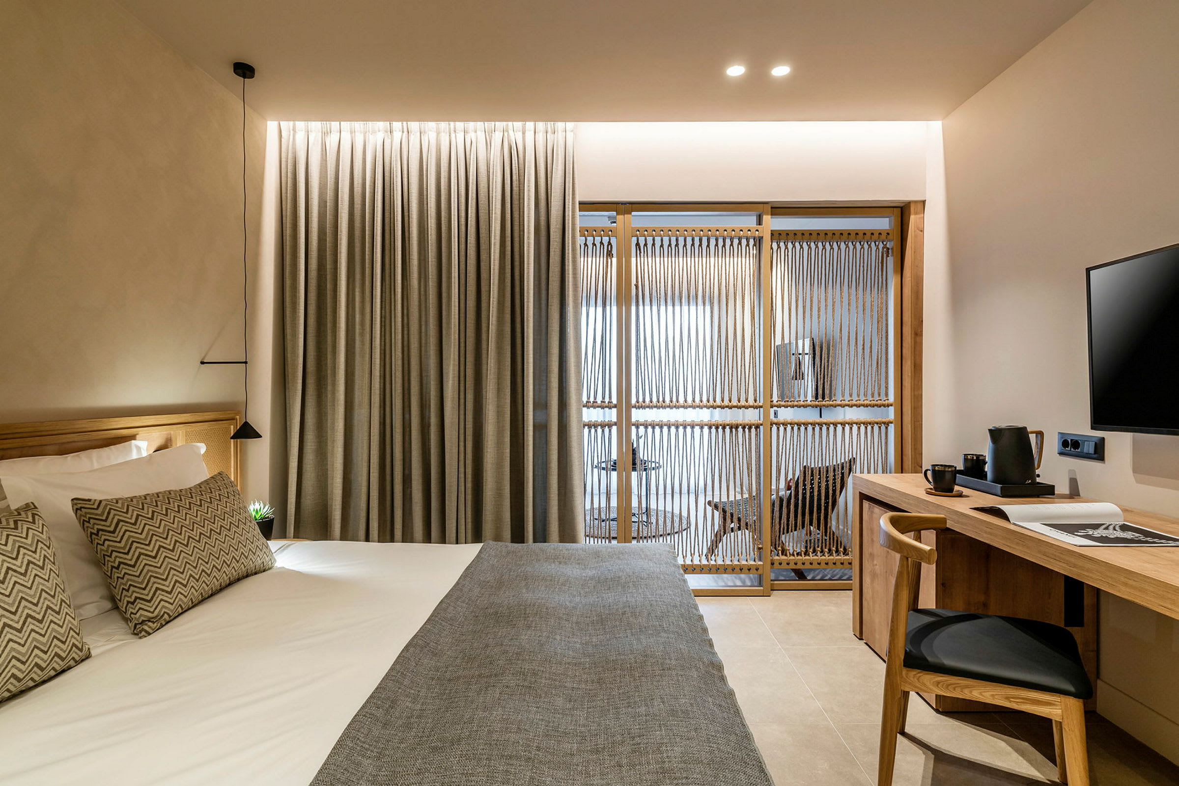 Hotellrom med moderne innredning, inkludert seng, skrivebord og skillevegg. (AI-generert tekst)
