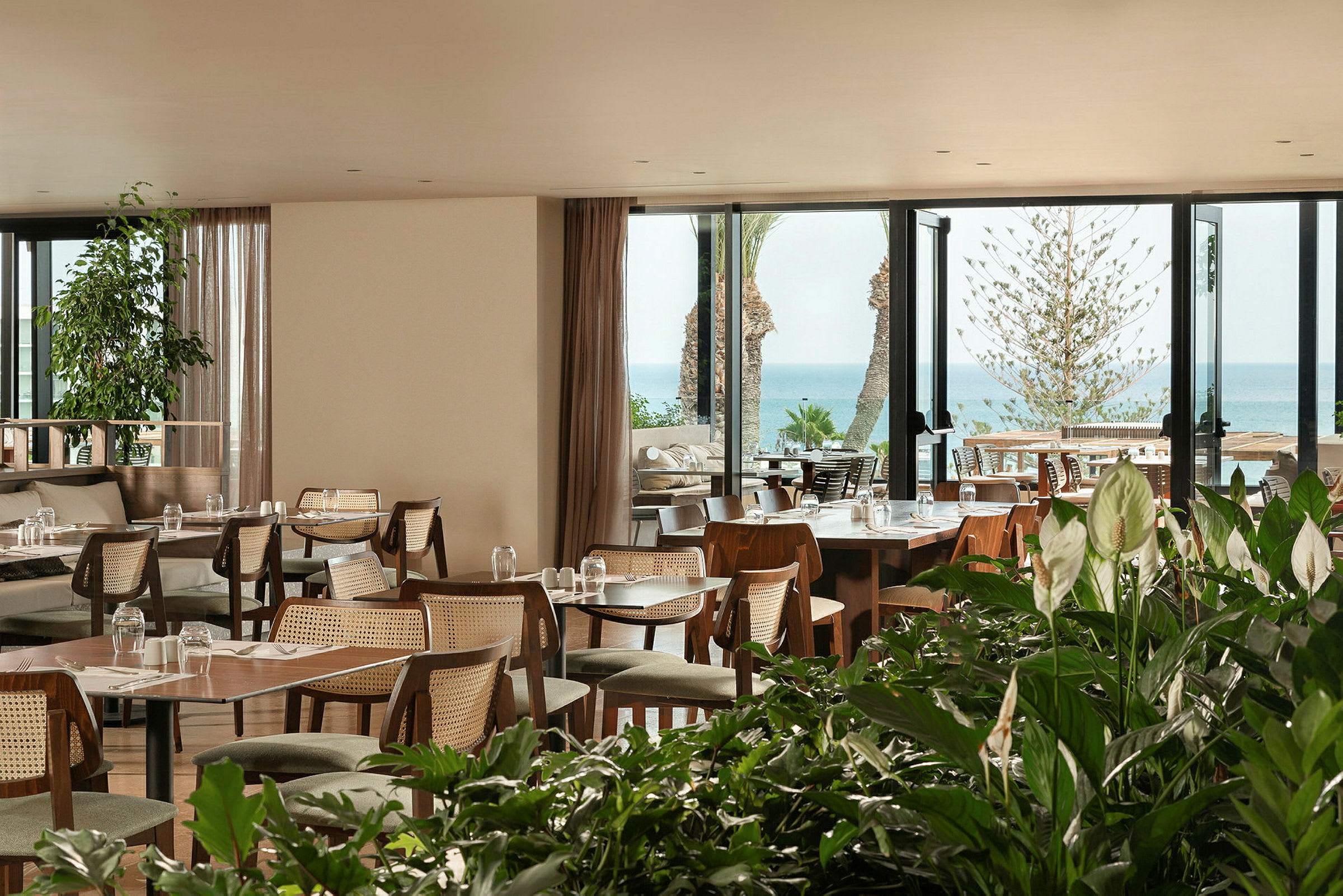 En restaurant med utsikt over havet og omgitt av grøntområder. (AI-generert tekst)
