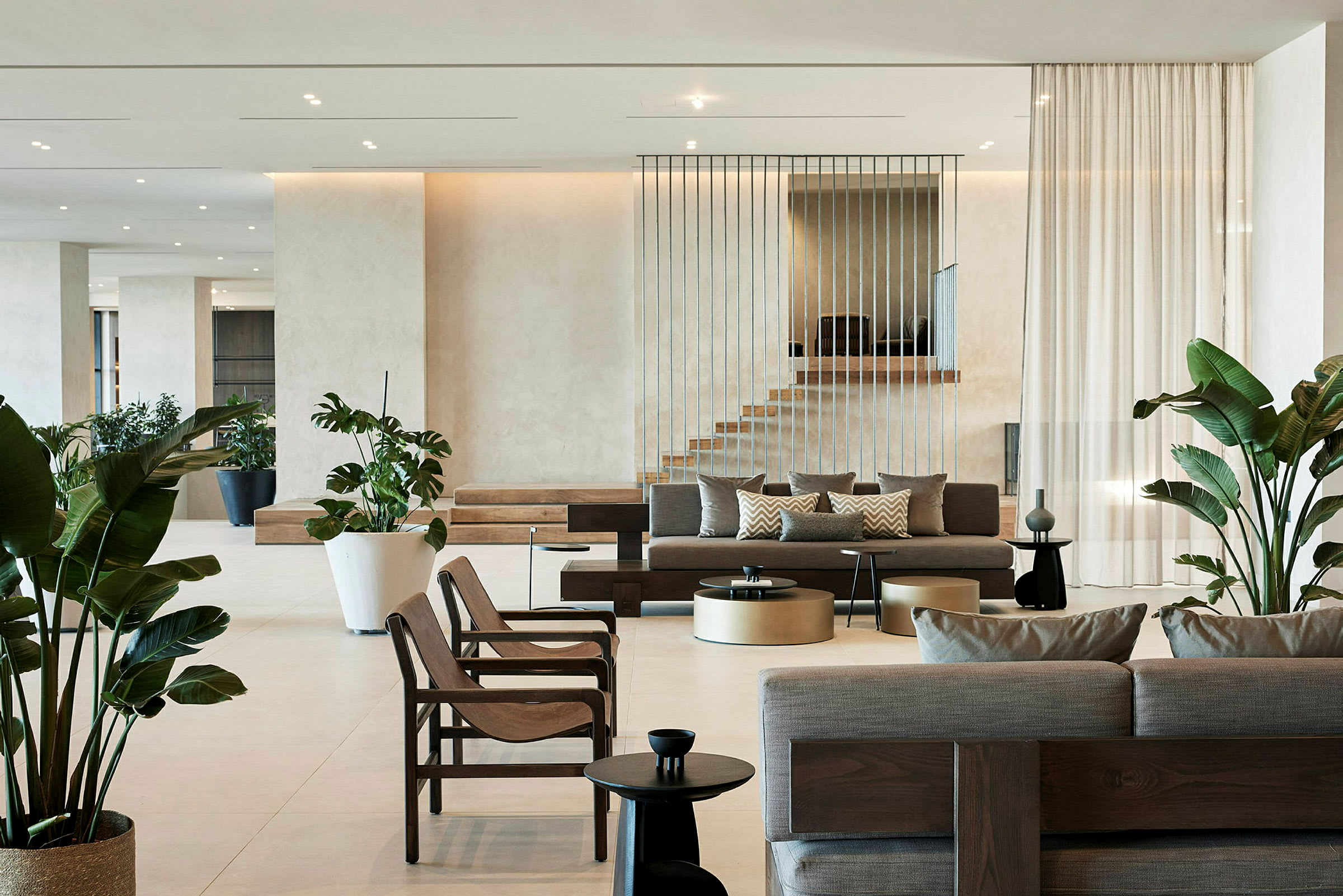 Moderne hotellobby med sofaer, stoler og grønne planter. (AI-generert tekst)
