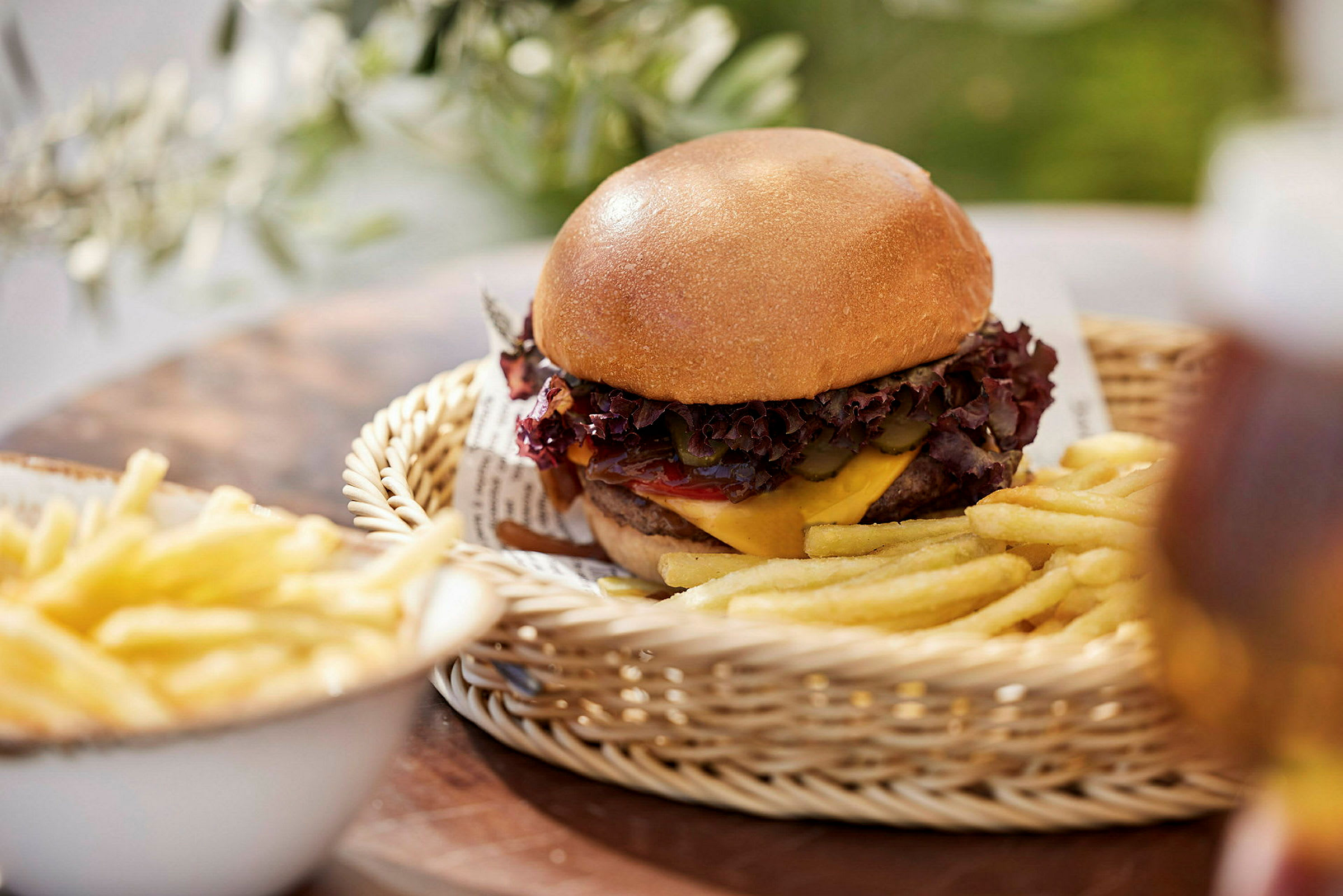 En hamburger med pommes frites servert i en kurv. (AI-generert tekst)
