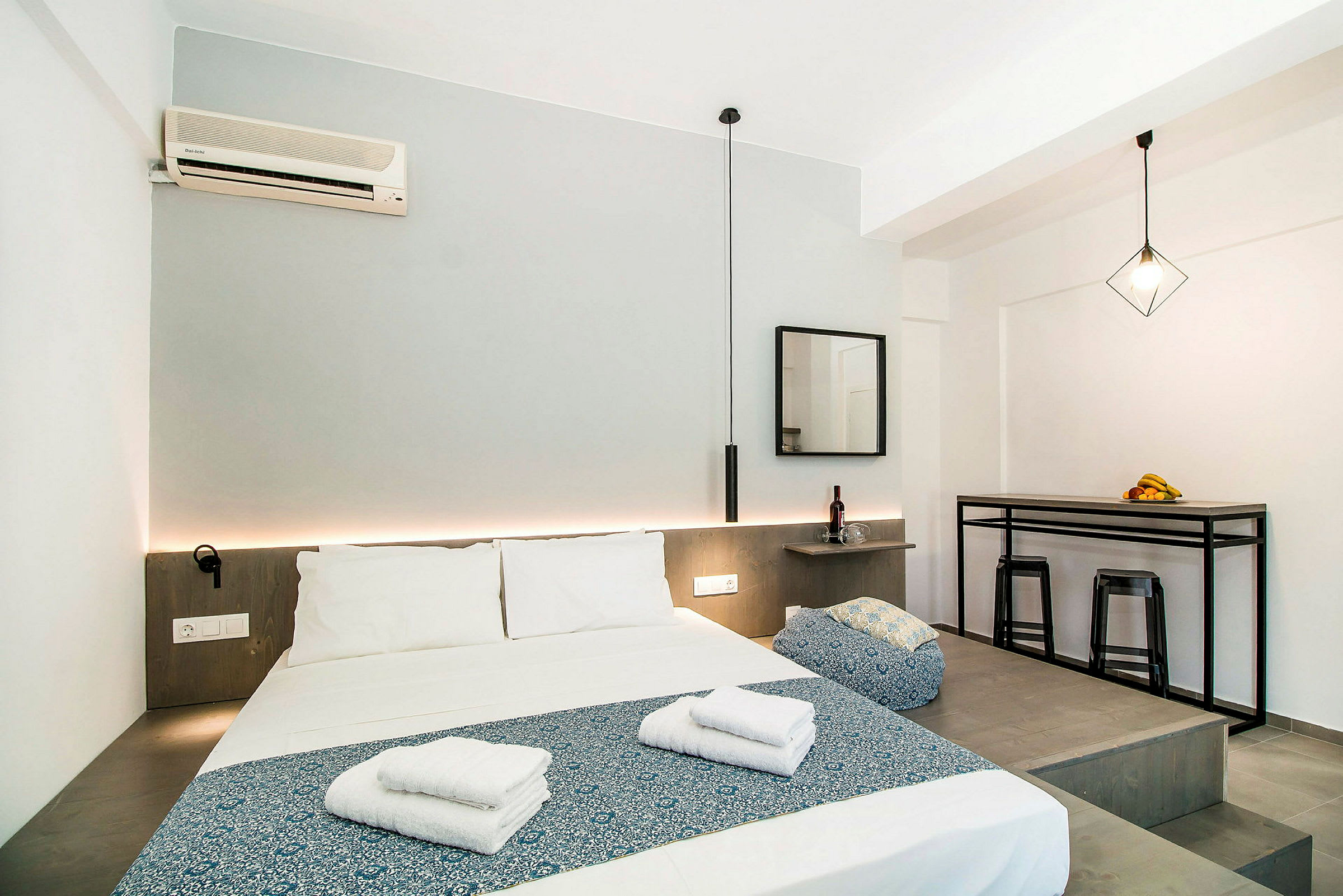 Et moderne hotellrom med oppredd seng, bord og stoler. (AI-generert tekst)