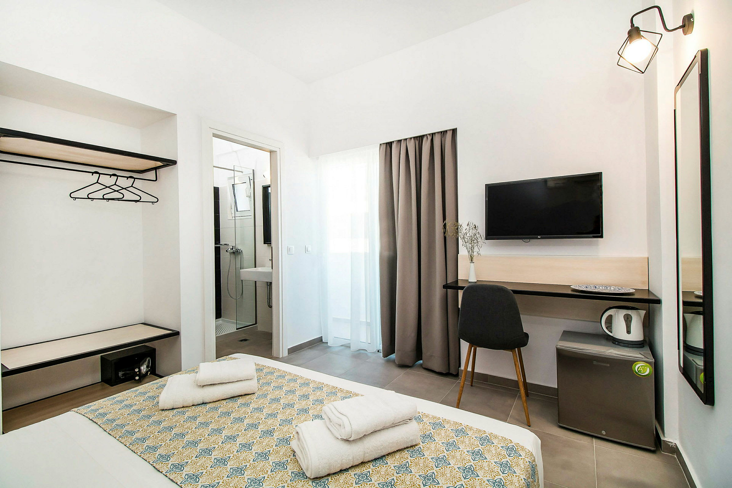 Hotellrom med seng, TV, skrivebord og bad. (AI-generert tekst)