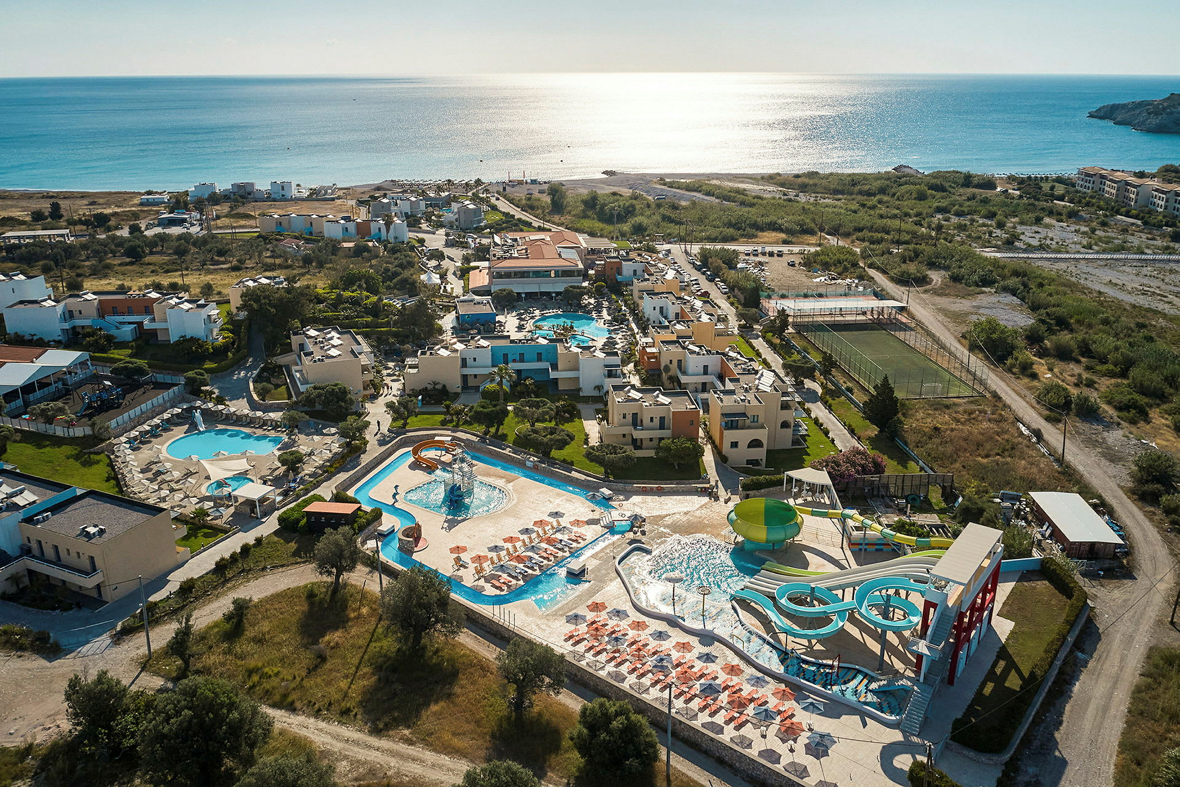 Luftbilde av en resort ved havet med bassengområder og vannsklier. (AI-generert tekst)