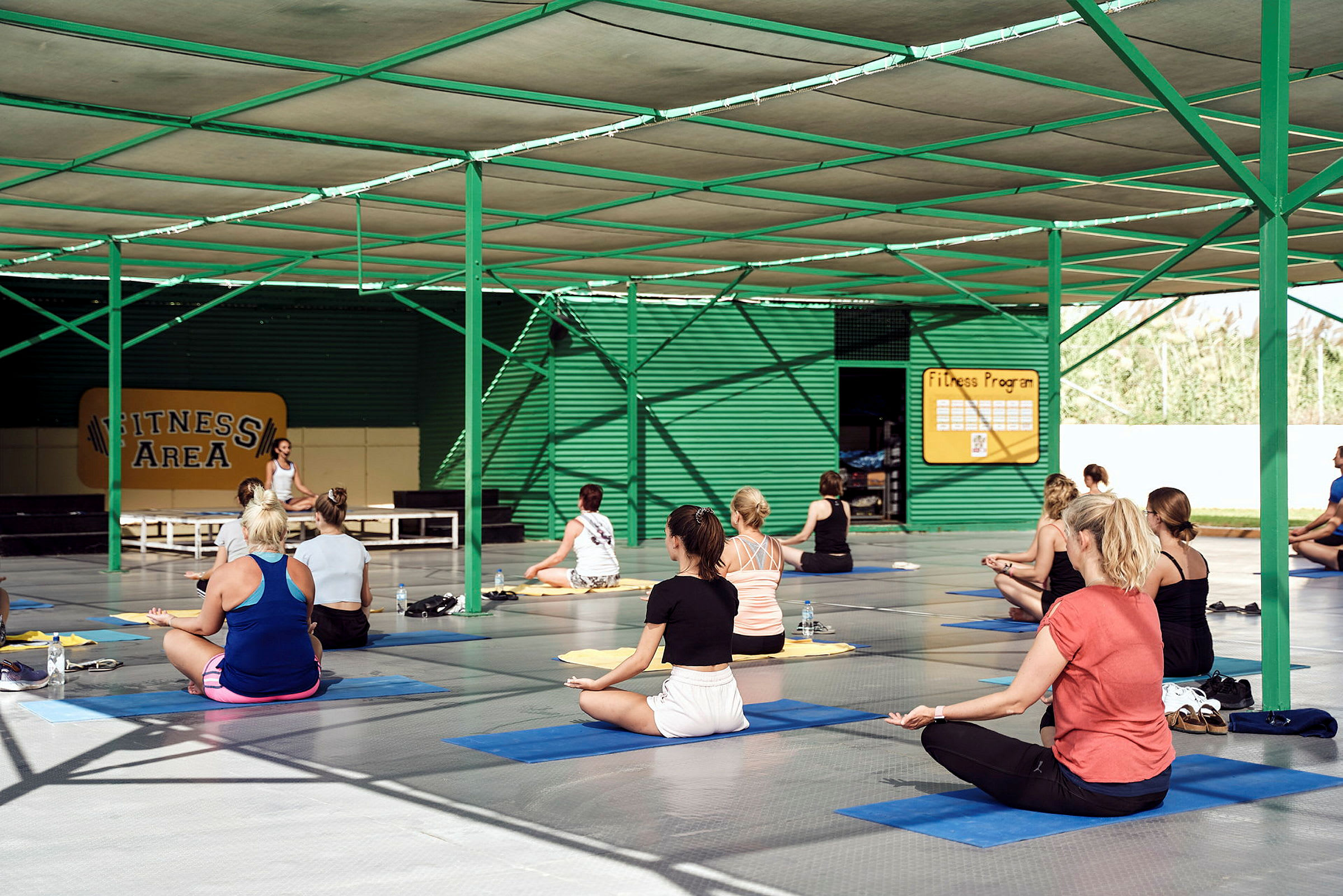Personer utfører trening på yogamatter i en innendørs fitnessområde. (AI-generert tekst)