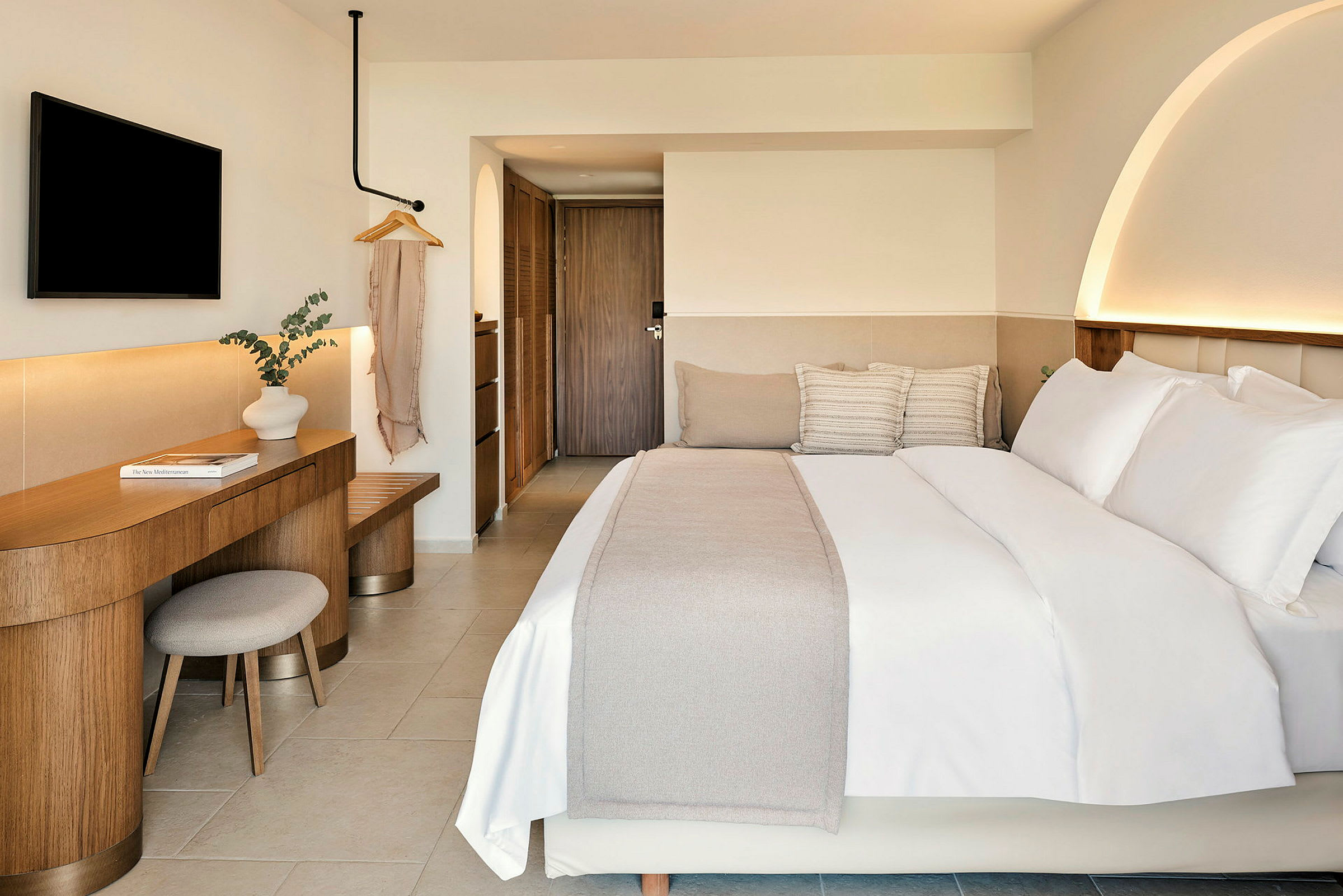 Et hotellrom med moderne innredning, en stor seng, skrivebord og dekorasjon. (AI-generert tekst)