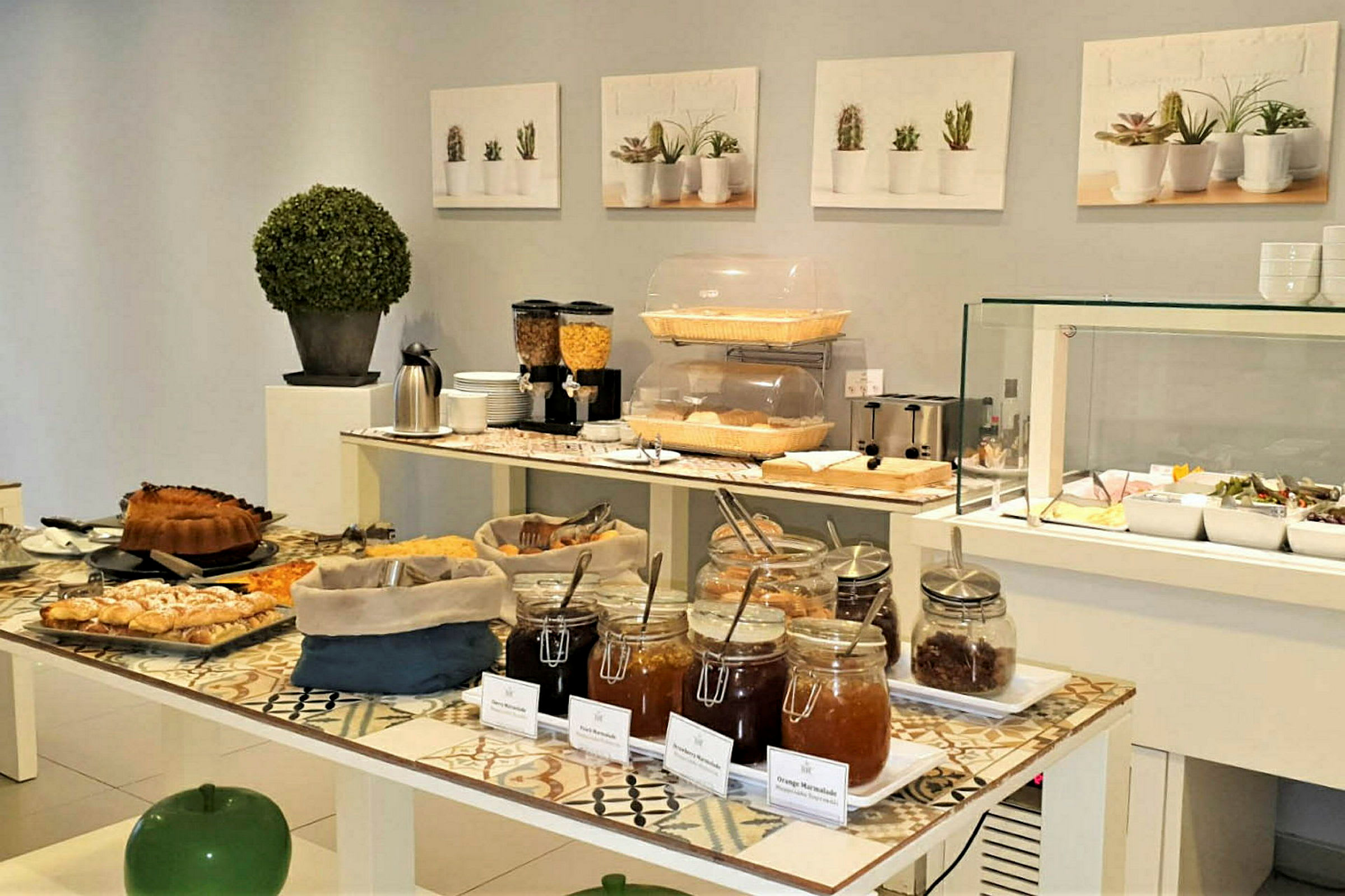 Frokostbuffé med brød, syltetøy og frokostblandinger. (AI-generert tekst)