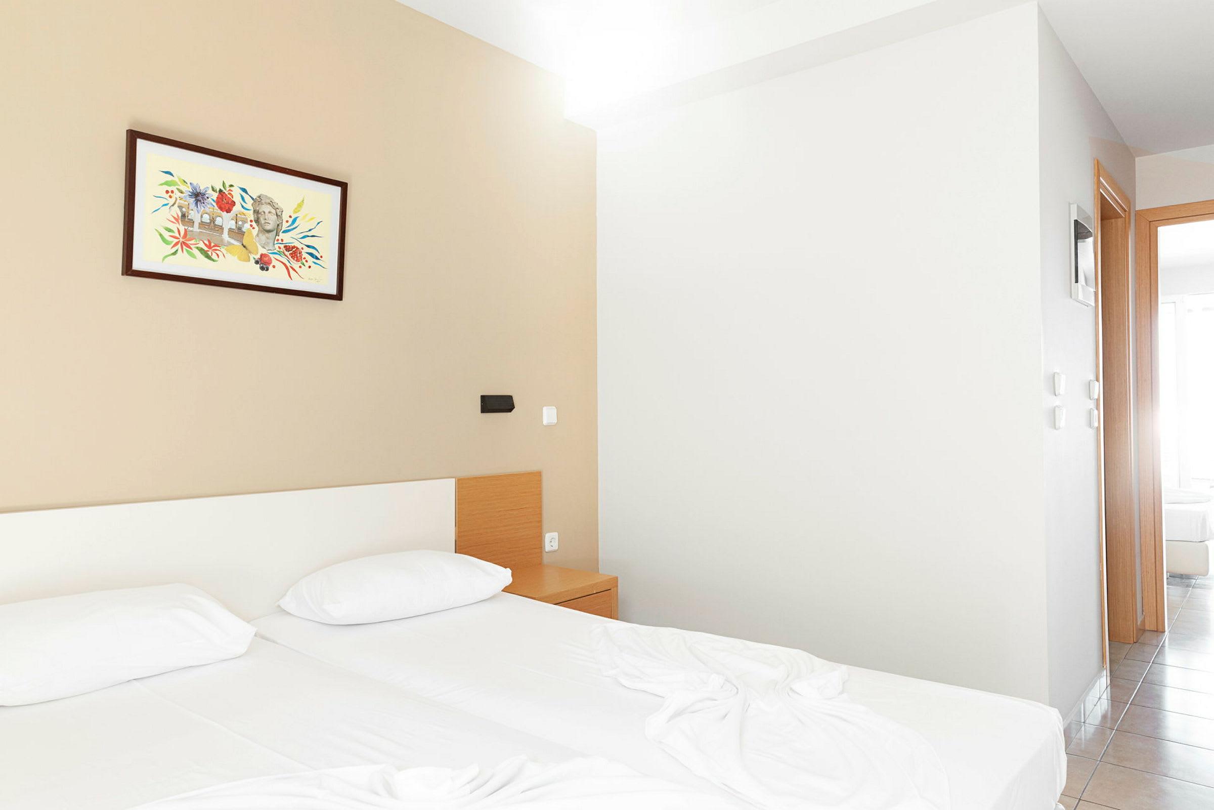 Et hotellrom med to senger, et nattbord og et maleri på veggen. (AI-generert tekst)