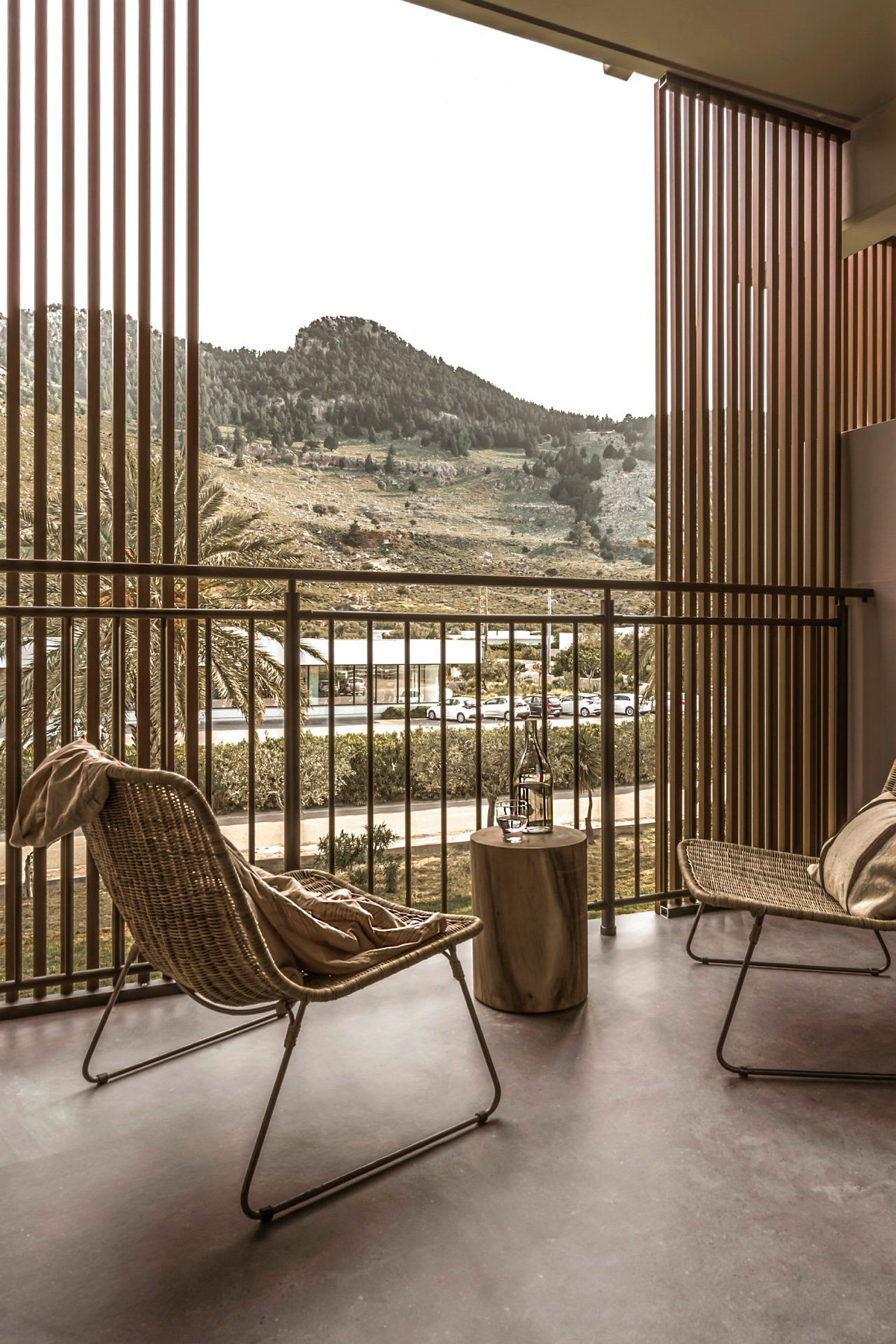 Terrasse med to stoler, et bord og utsikt mot et fjellområde. (AI-generert tekst)