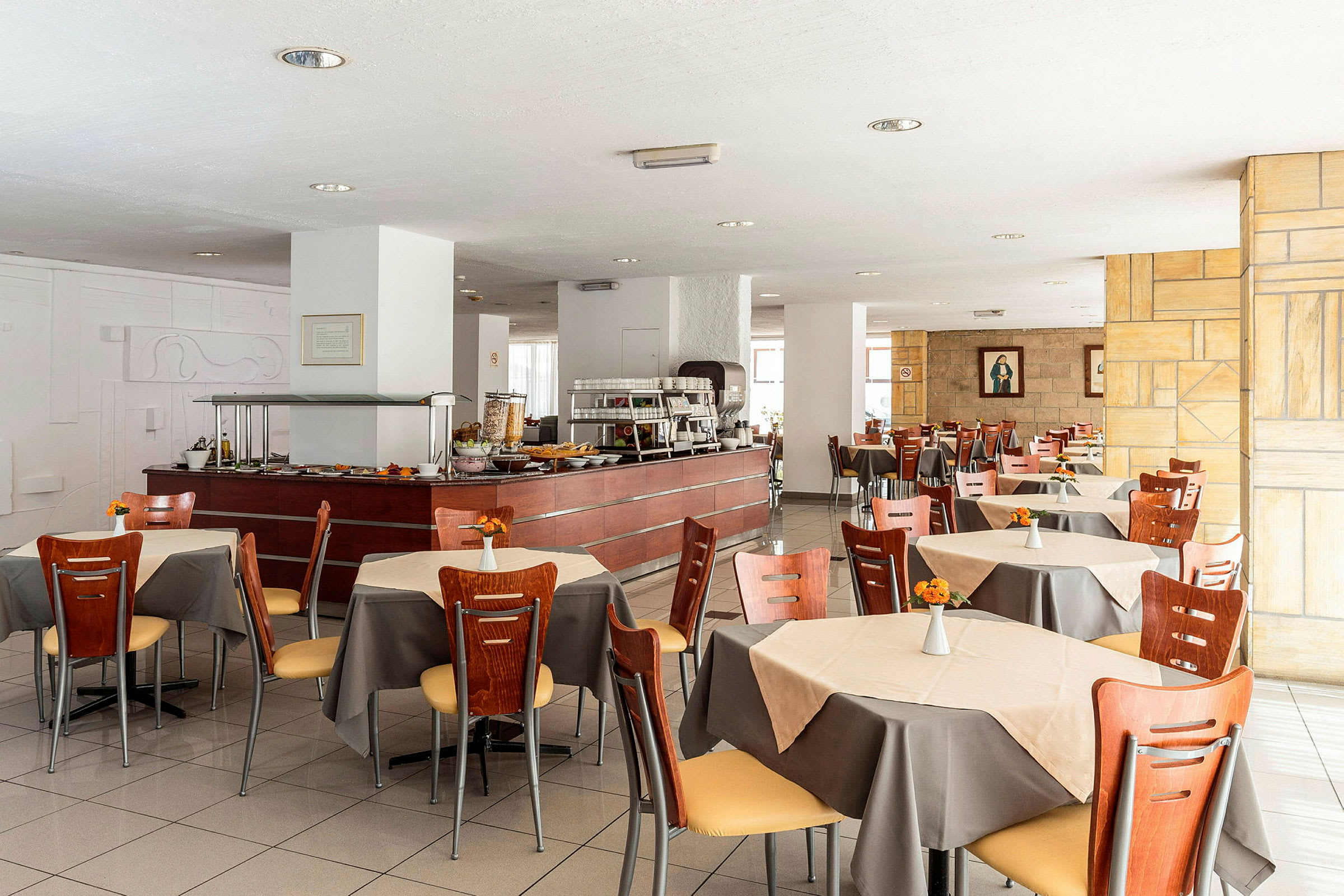 Spisesal i restauranten med bord, stoler og en buffédisk. (AI-generert tekst)