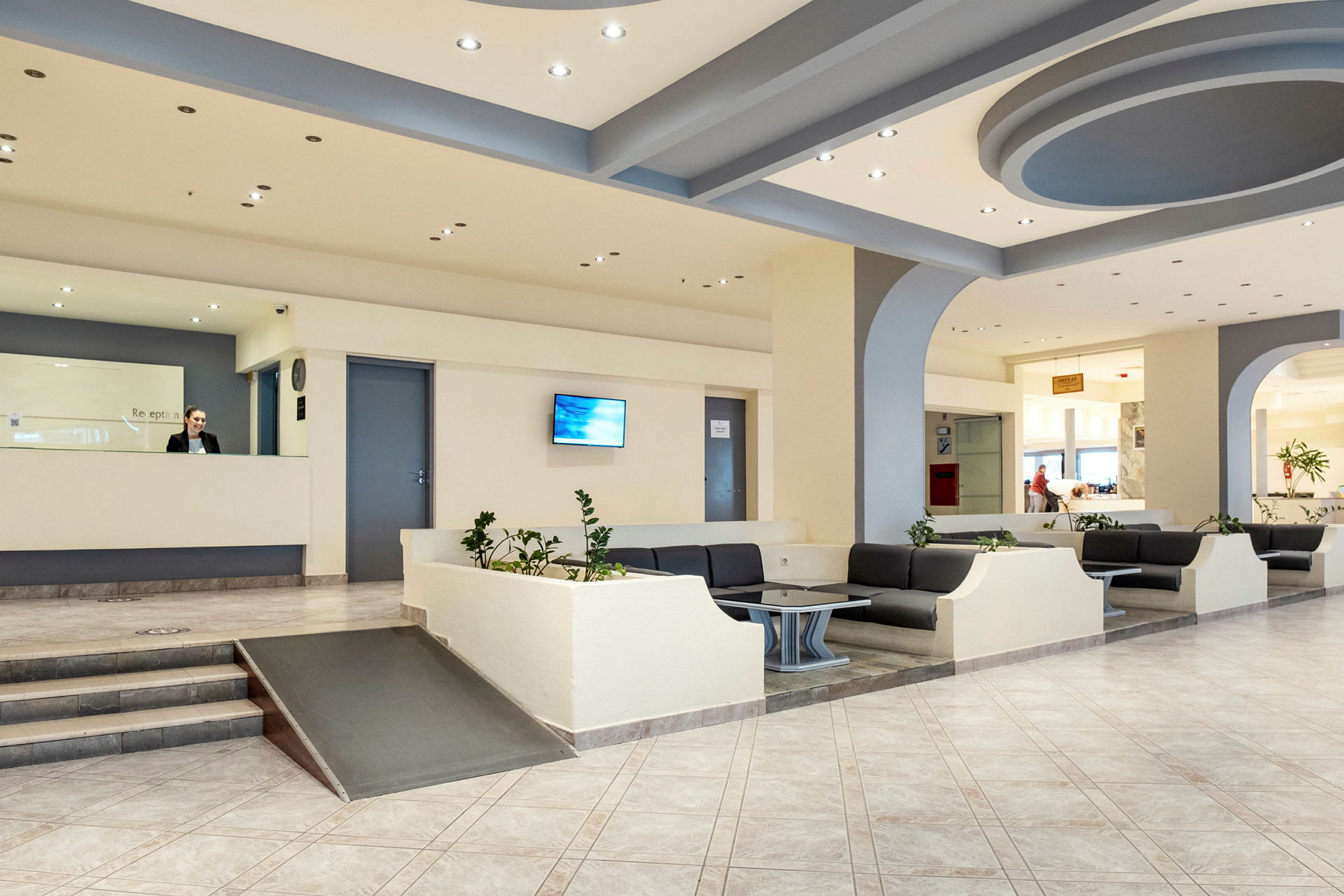Hotellobby med resepsjon og sitteområder. (AI-generert tekst)