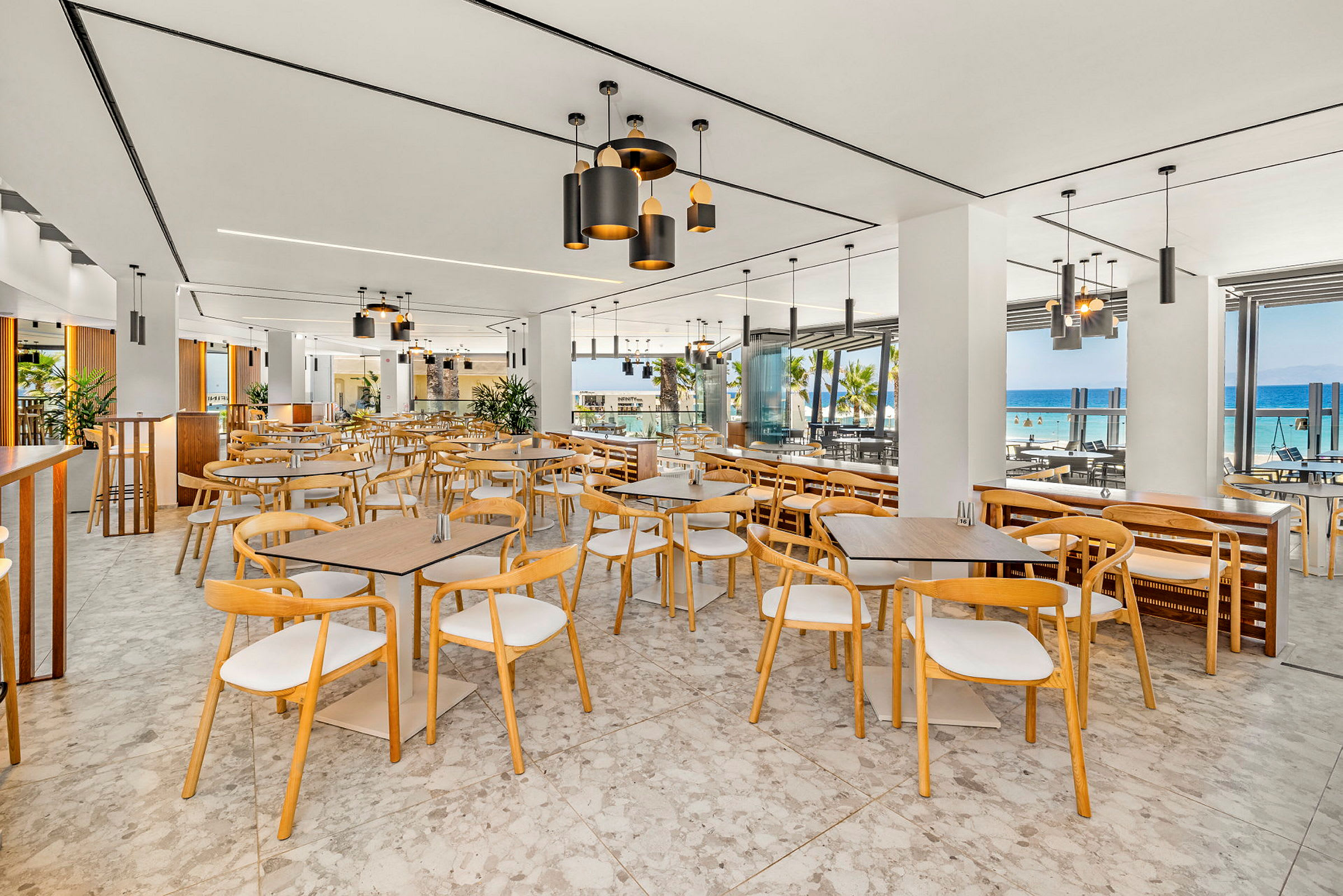 Restaurant med moderne møbler og store vinduer med utsikt over havet. (AI-generert tekst)