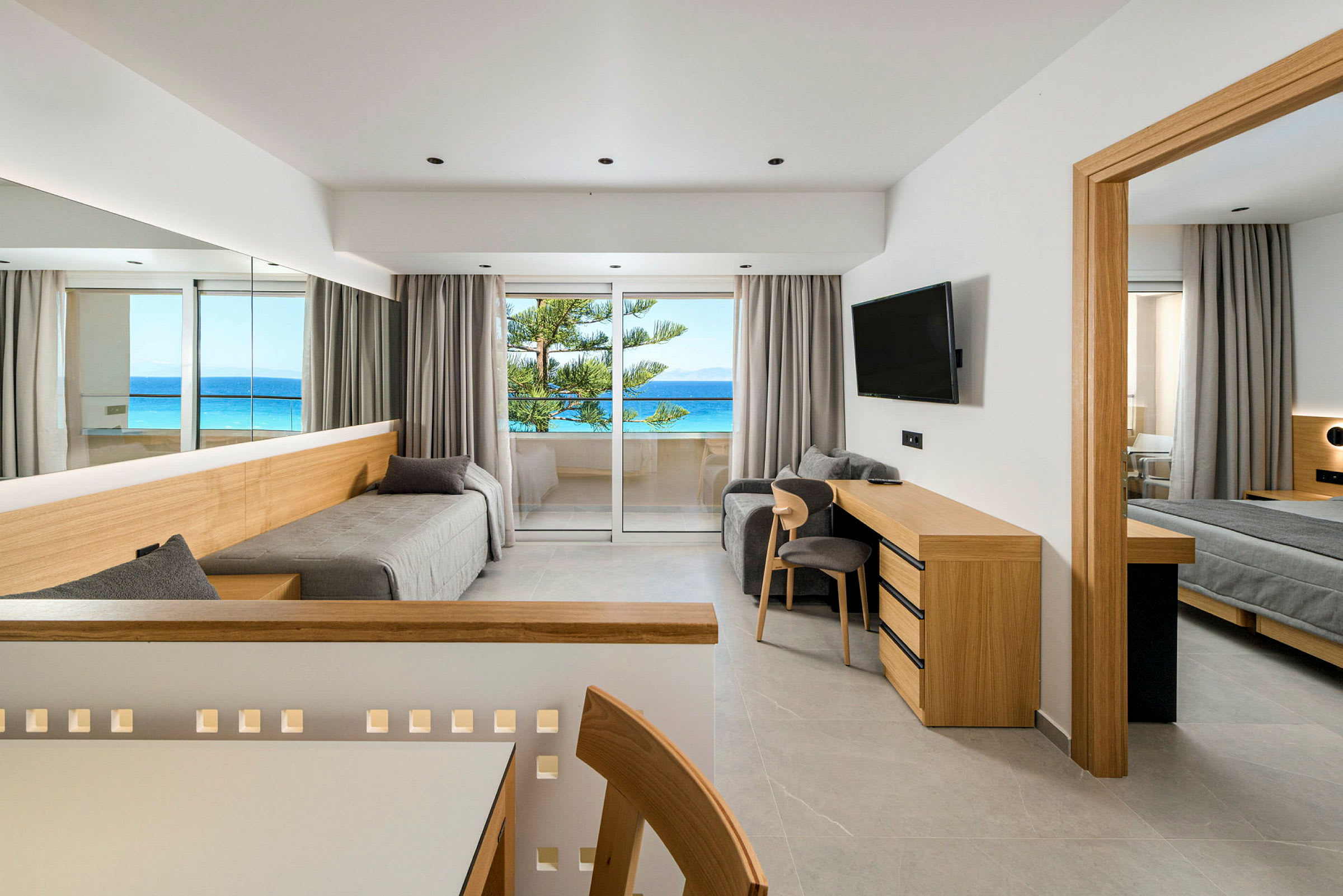 Et moderne hotellrom med skandinavisk innredning og utsikt over havet fra balkongen. (AI-generert tekst)