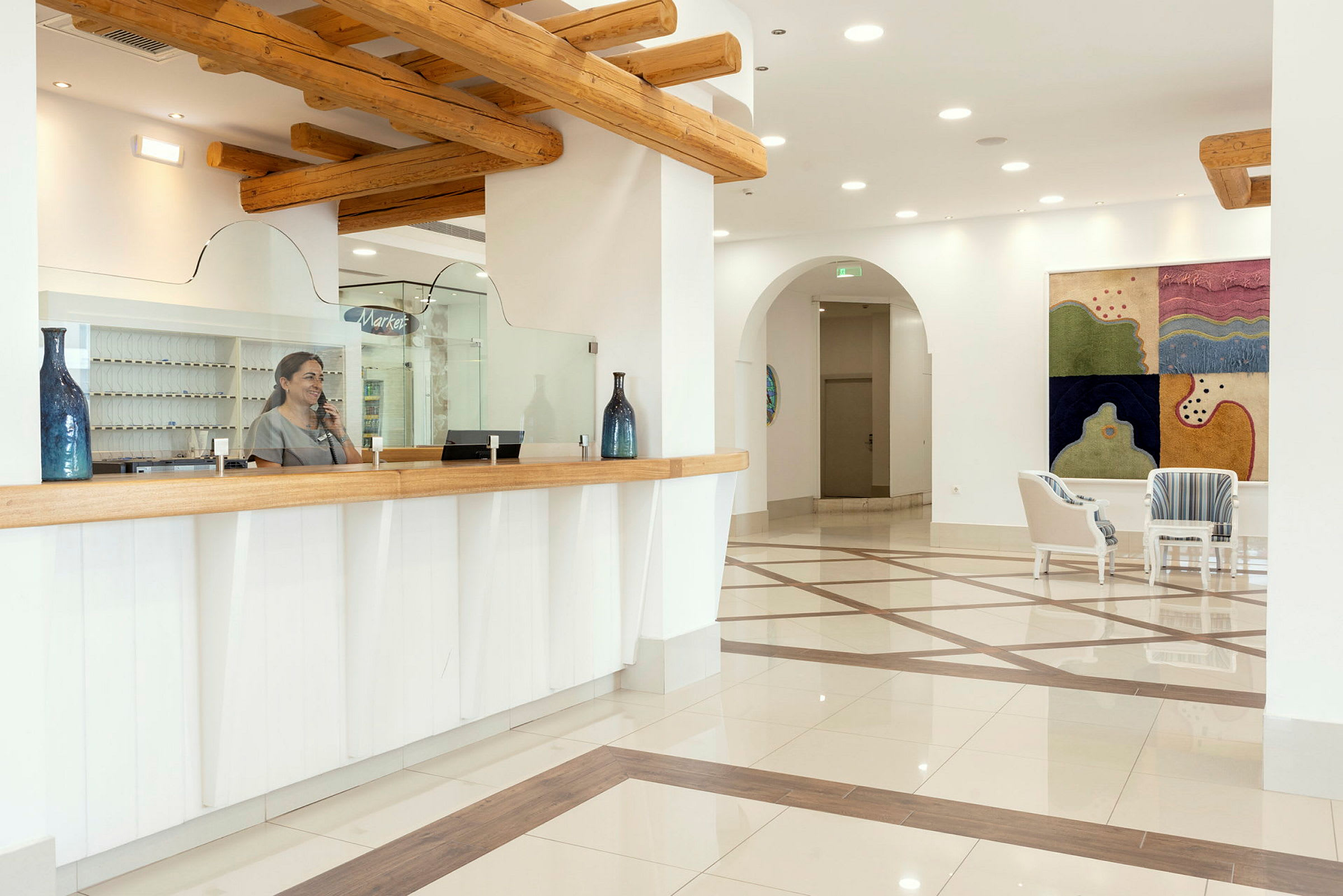 Resepsjon med glassfront, tremøbler og dekorasjoner i en hotellobby. (AI-generert tekst)