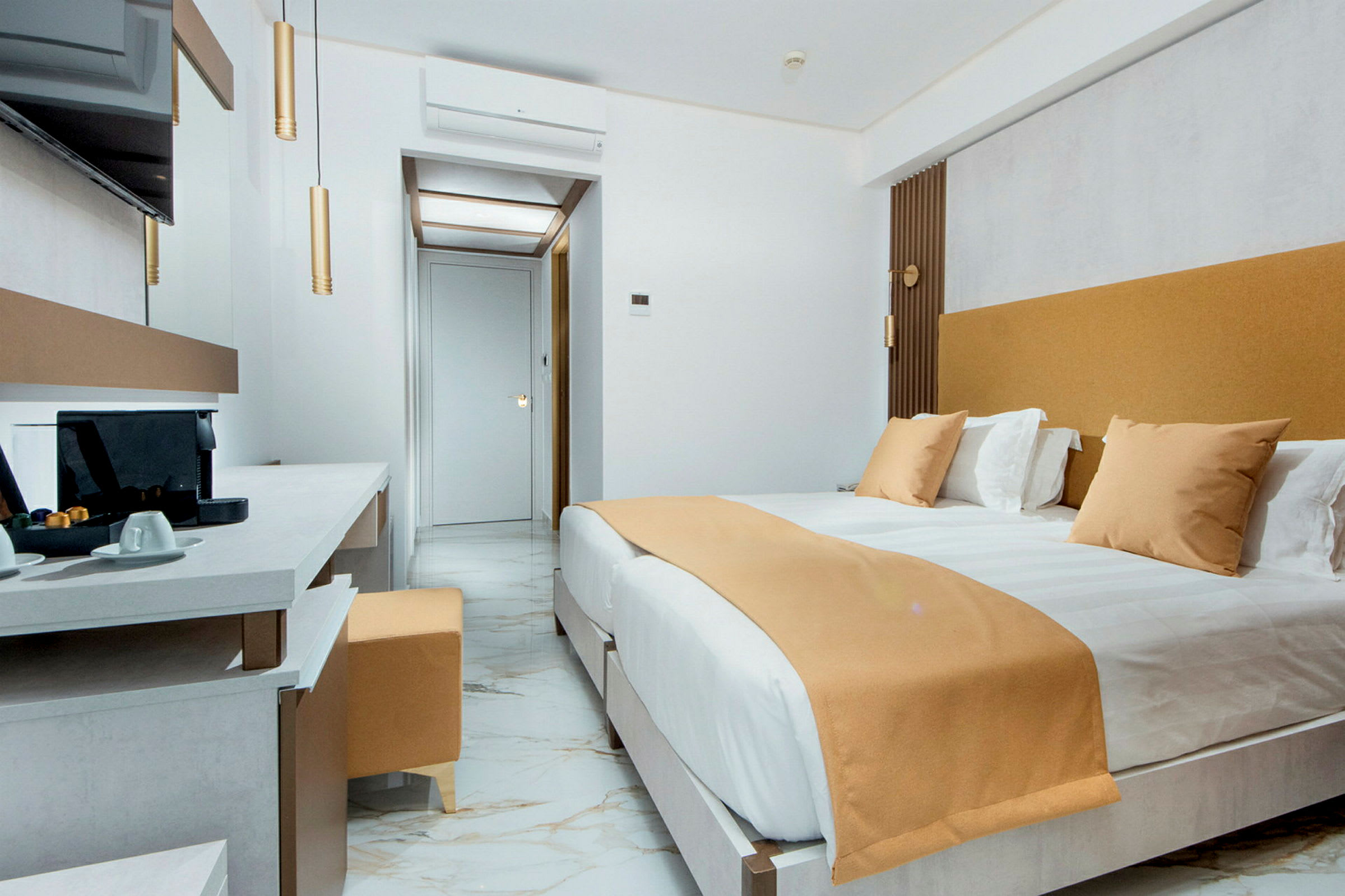Et moderne hotellrom med en stor seng, marmorgulv og en arbeidsplass med kaffemaskin. (AI-generert tekst)