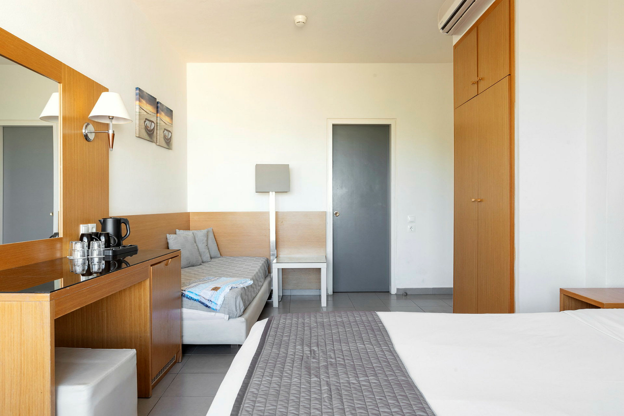 Et hotellrom med seng, garderobe og skrivebord. (AI-generert tekst)