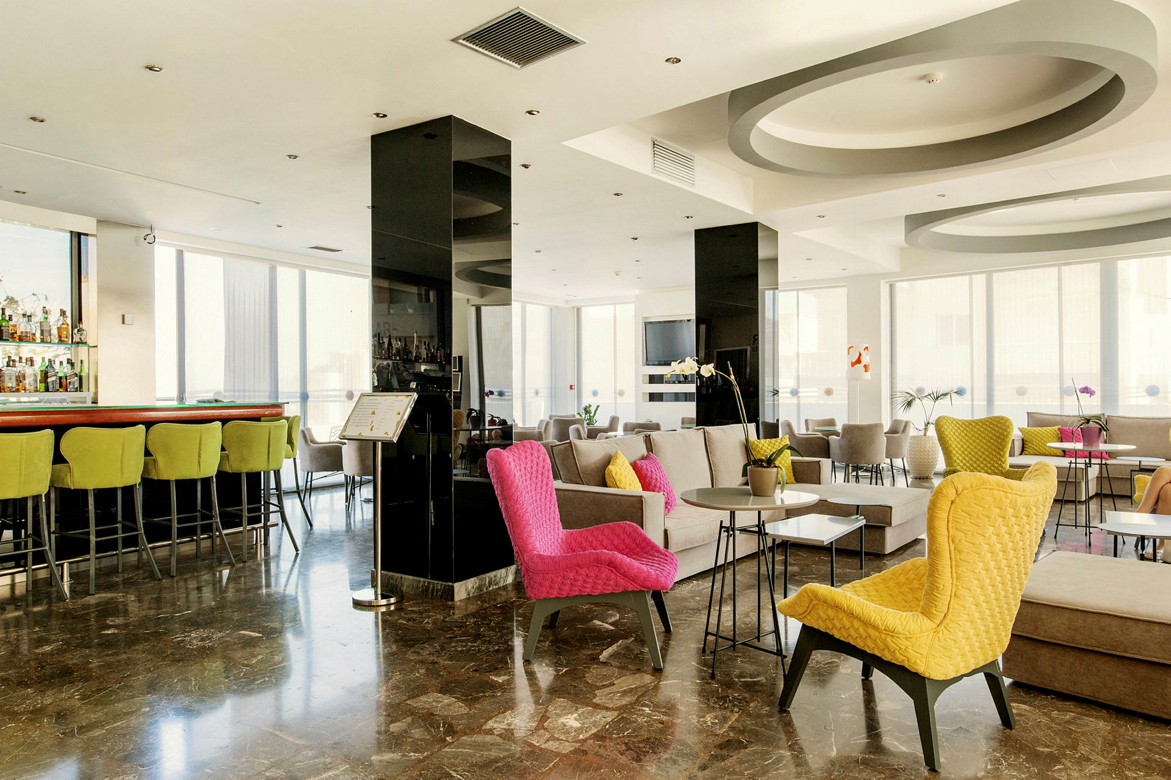 Interiøren av en moderne hotellobby med fargerike stoler og sittegrupper. (AI-generert tekst)