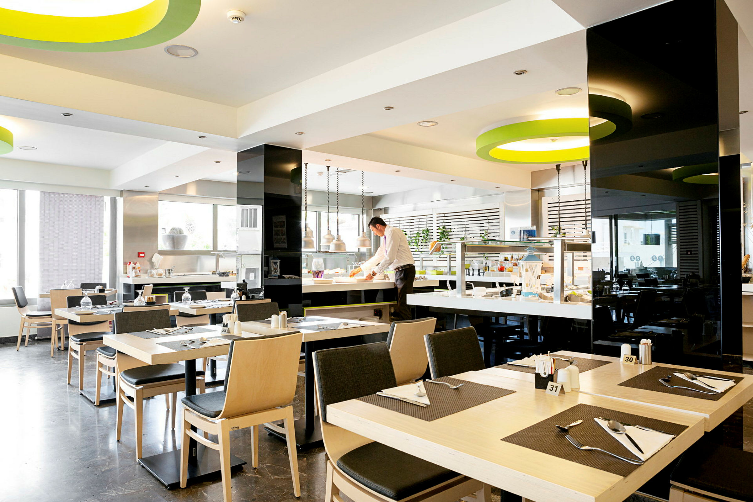 Moderne og lyse restaurantlokaler med dekte bord og et serveringsområde. (AI-generert tekst)