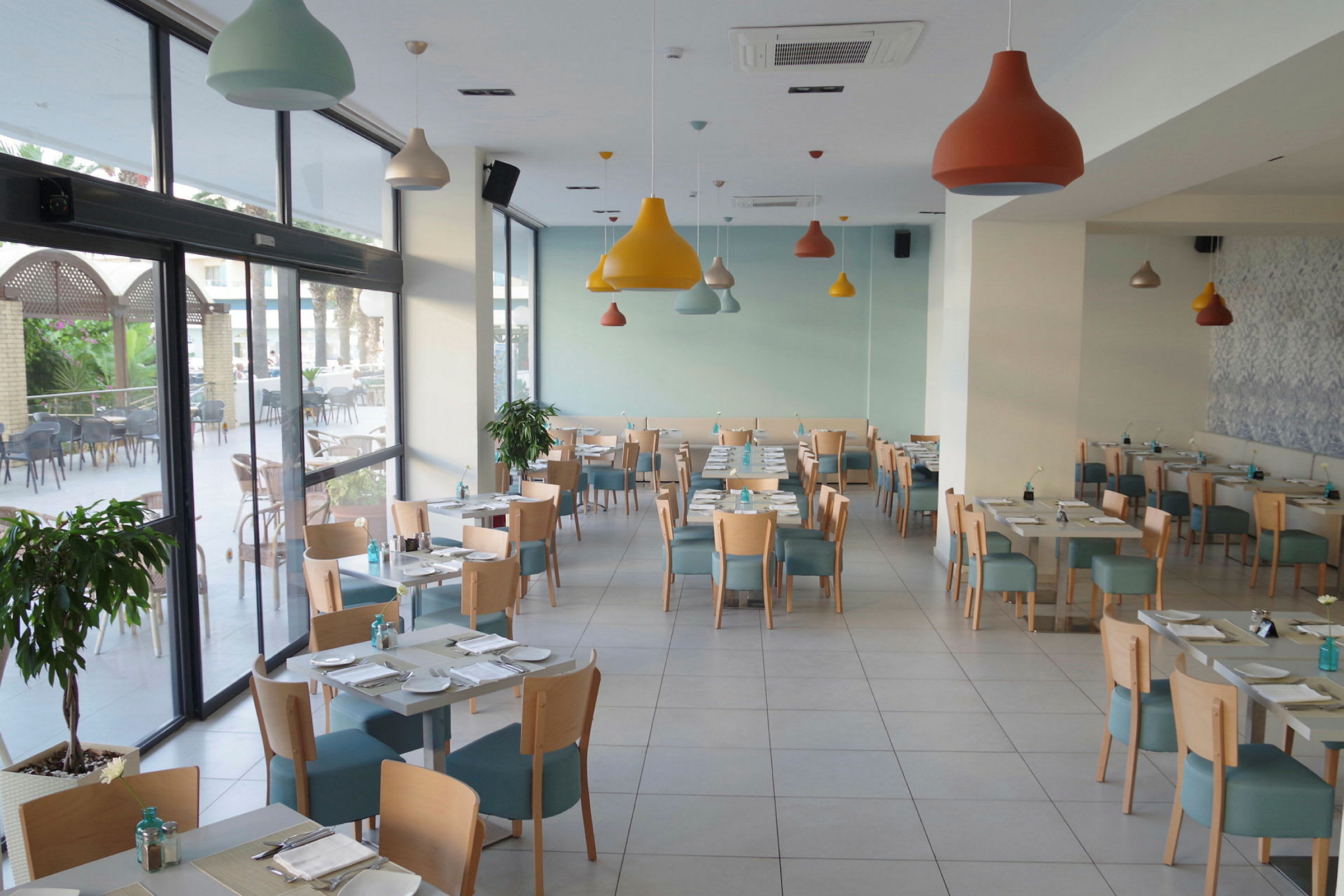 En lys og moderne restaurant med bord og stoler plassert. (AI-generert tekst)