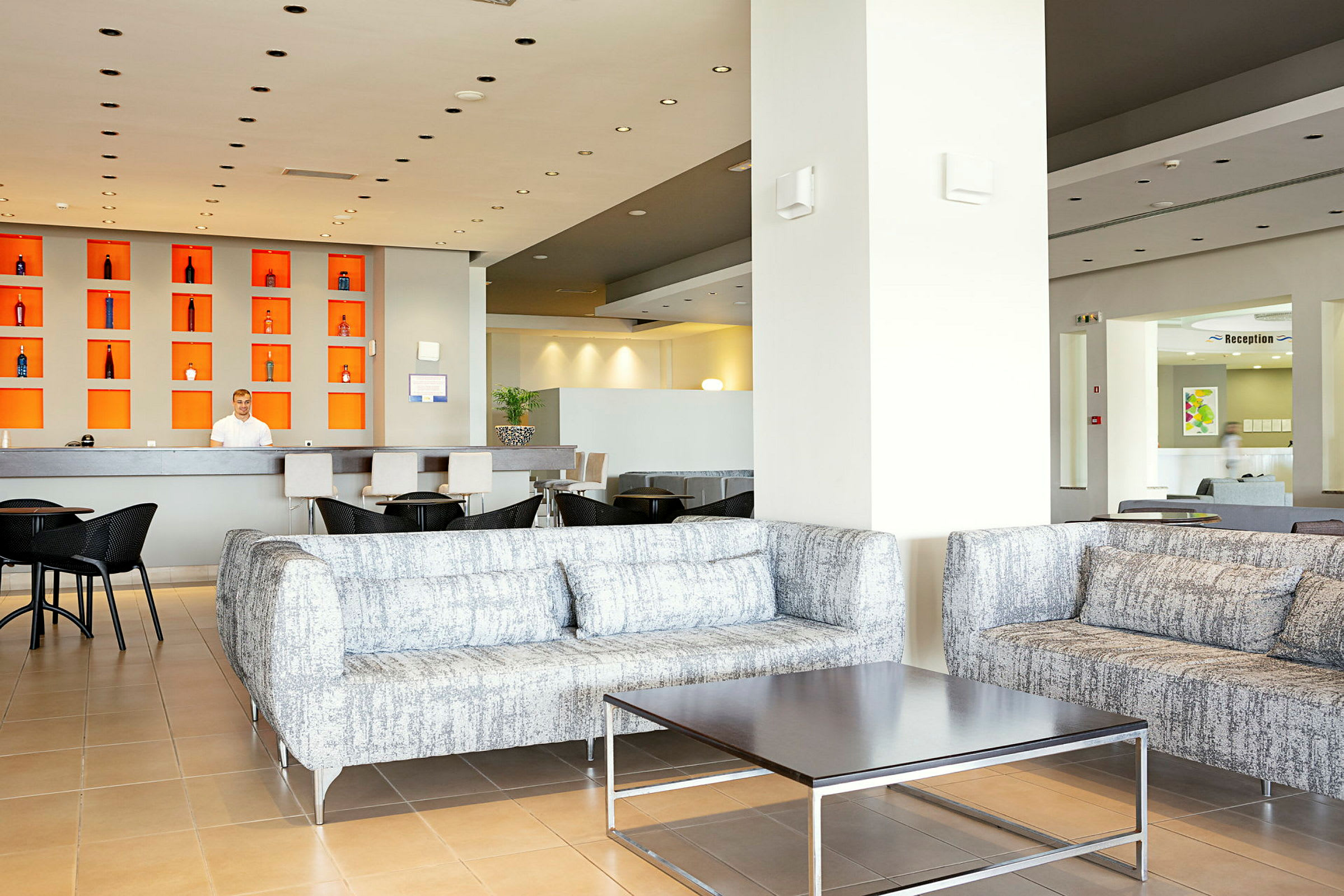 Luftig hotellobby med sofagrupper og resepsjonsdisk. (AI-generert tekst)
