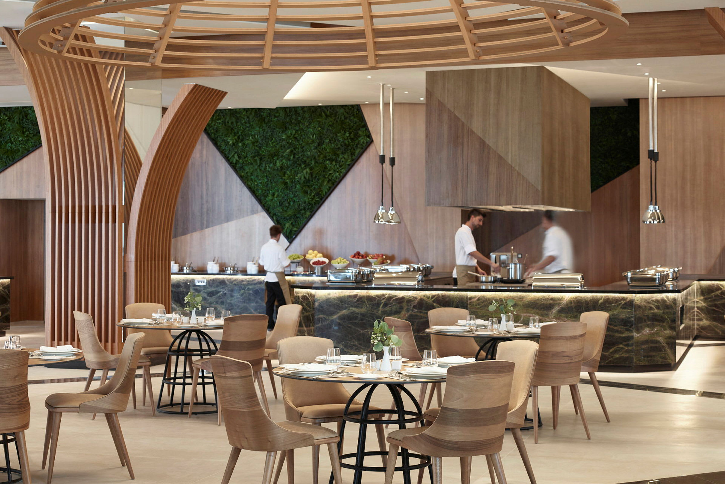 En restaurant med moderne tredetaljer og planter på veggene. Mat er servert ved en buffé. (AI-generert tekst)