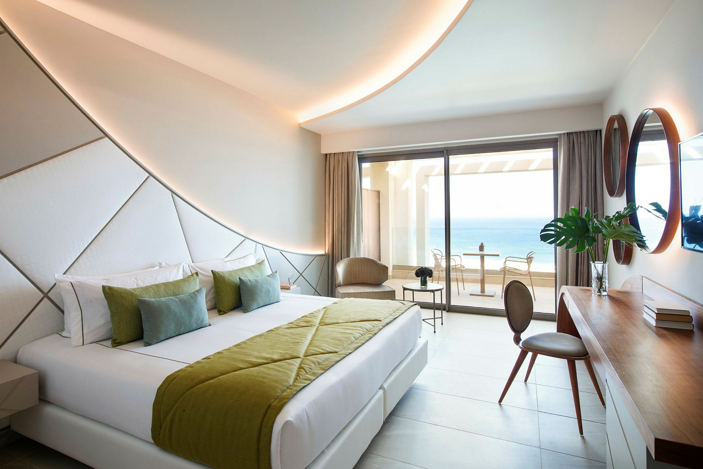 Moderne hotellrom med dobbeltseng og havutsikt fra balkongen. (AI-generert tekst)