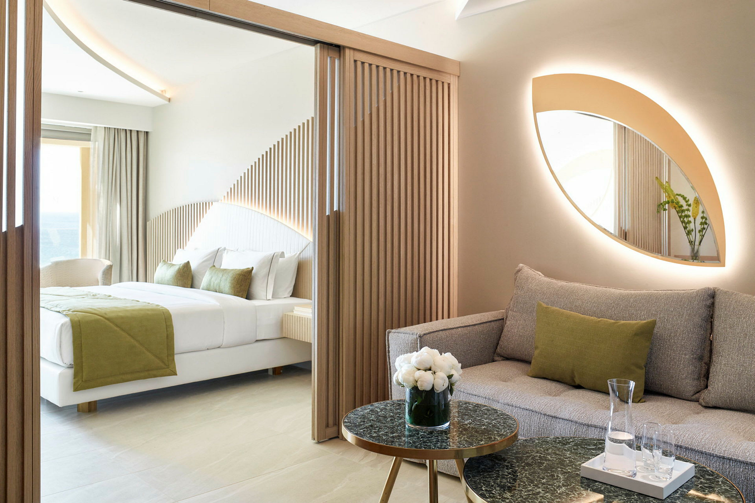 Moderne hotellrom med sofa og seng, dekorert med naturlige farger og treelementer. (AI-generert tekst)