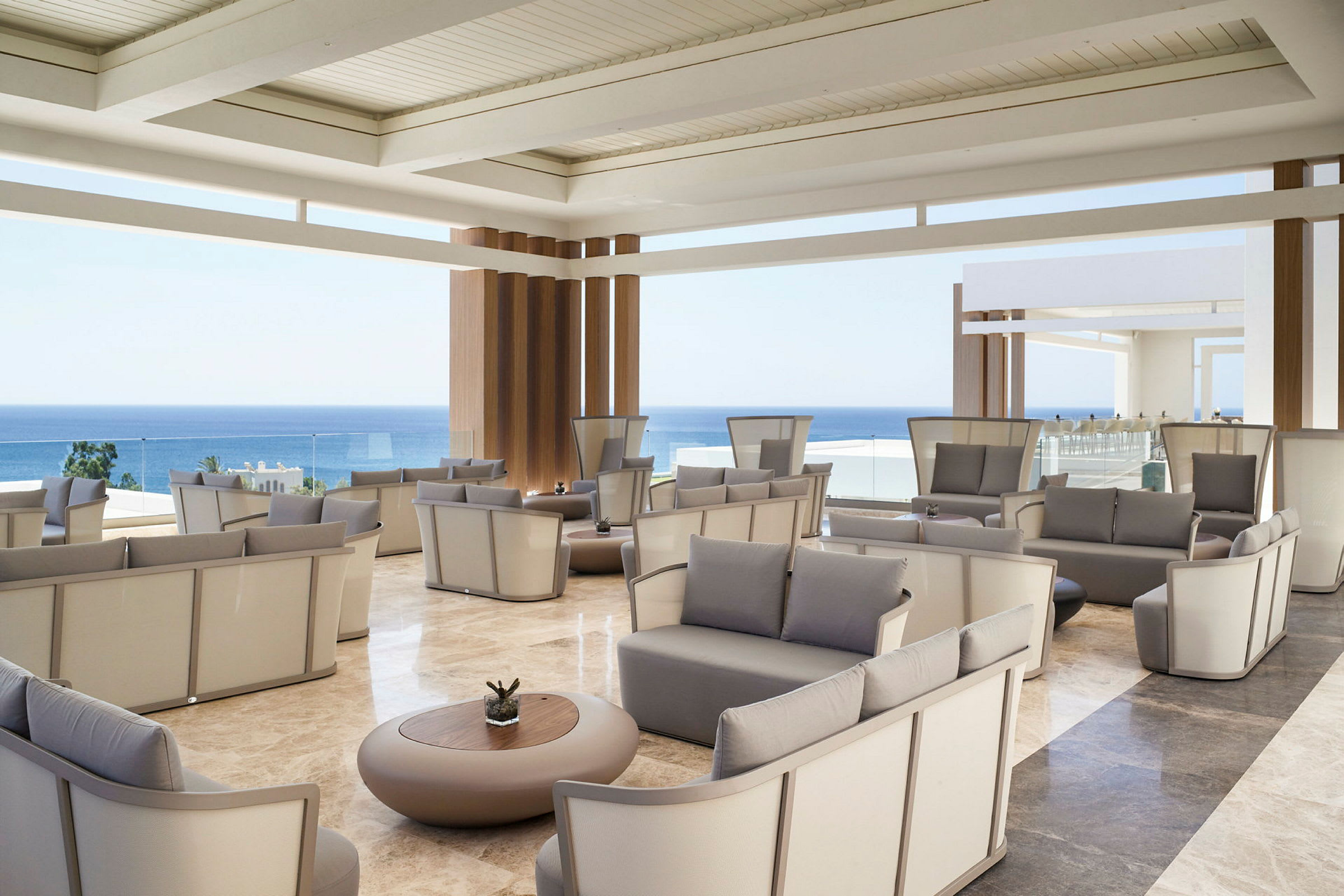 En romslig lounge med moderne design og utsikt over havet. (AI-generert tekst)