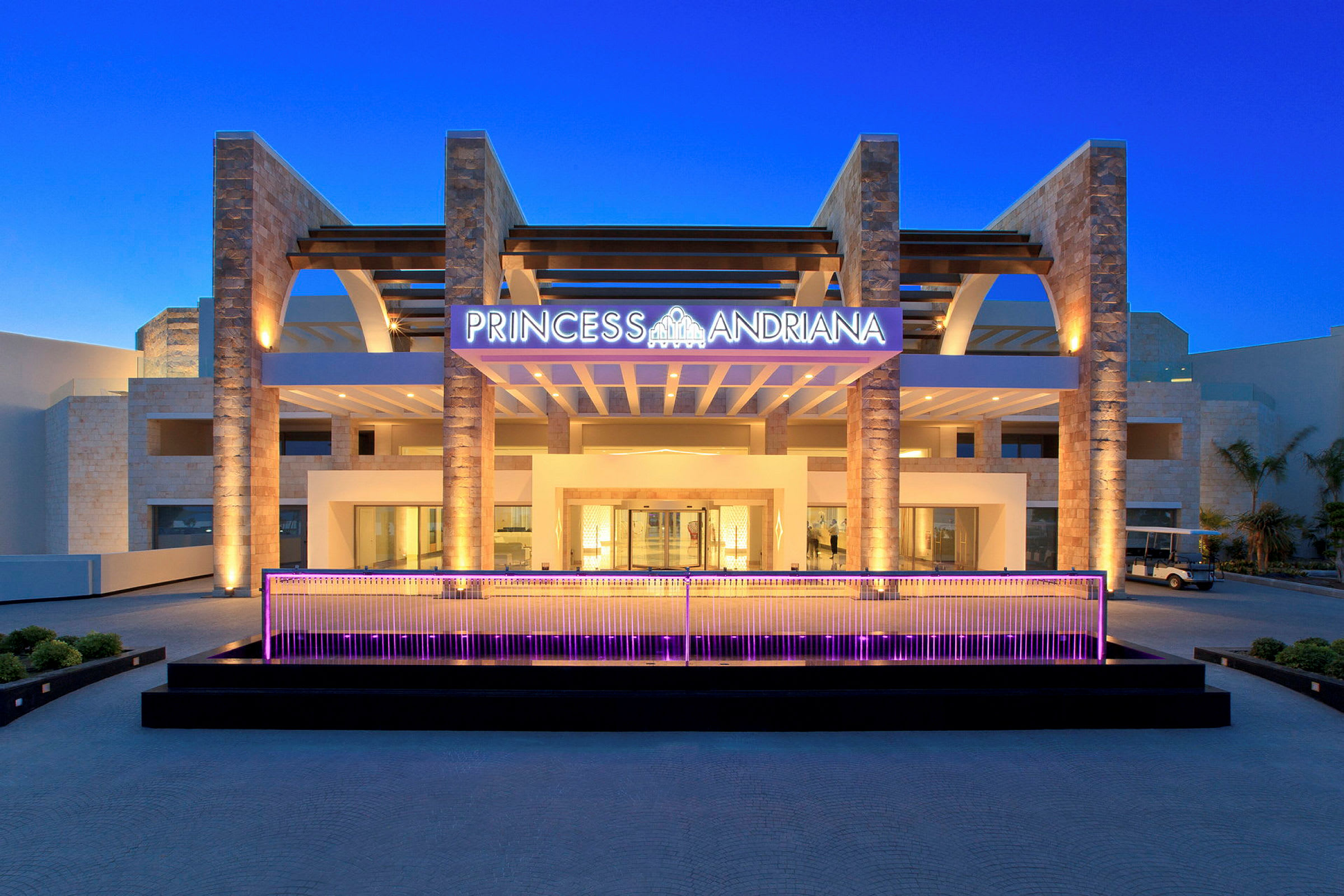 Hotellinngang med skiltet "Princess Andriana" og moderne arkitektur. (AI-generert tekst)