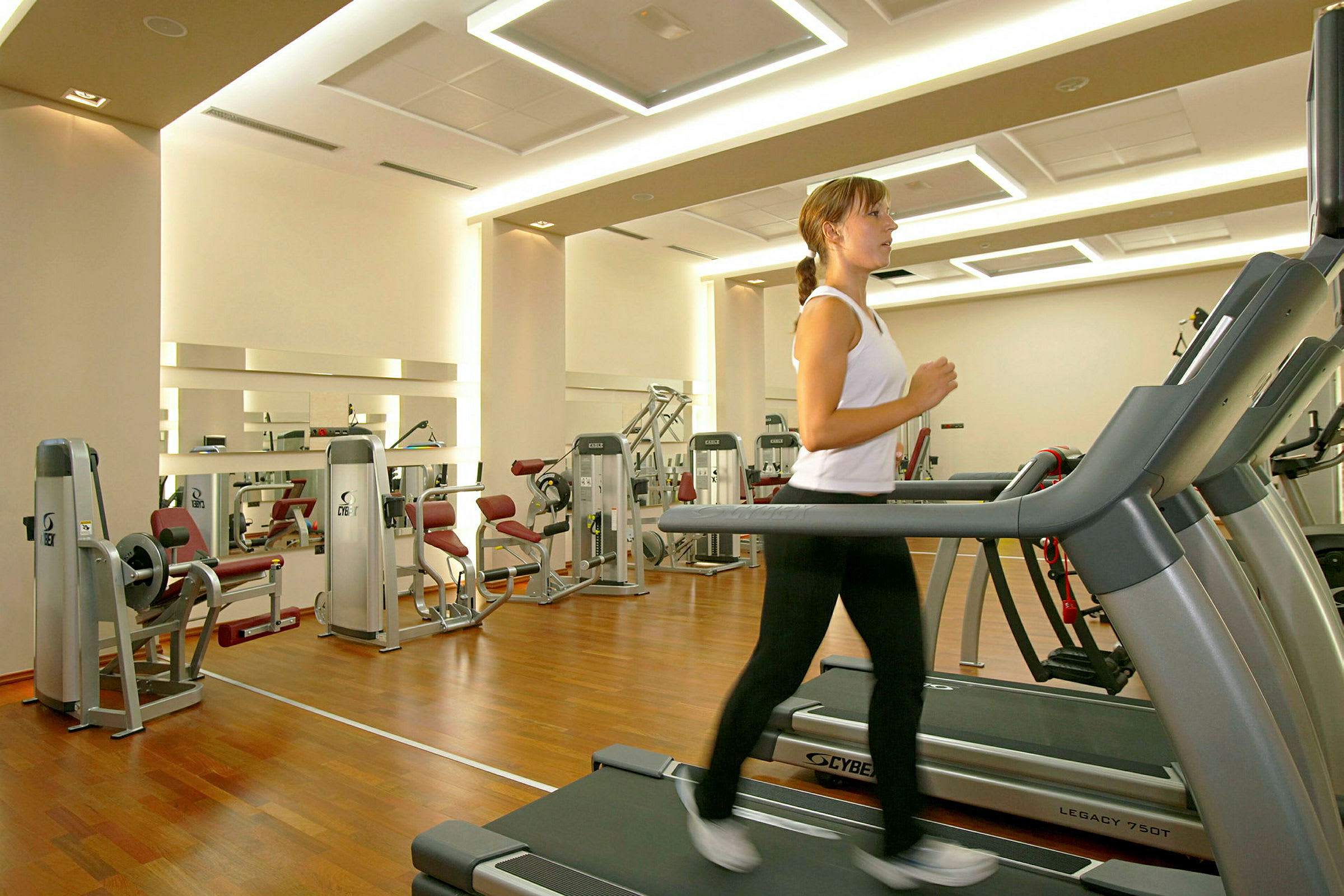 Gym med treningsutstyr og en person som løper på en tredemølle. (AI-generert tekst)