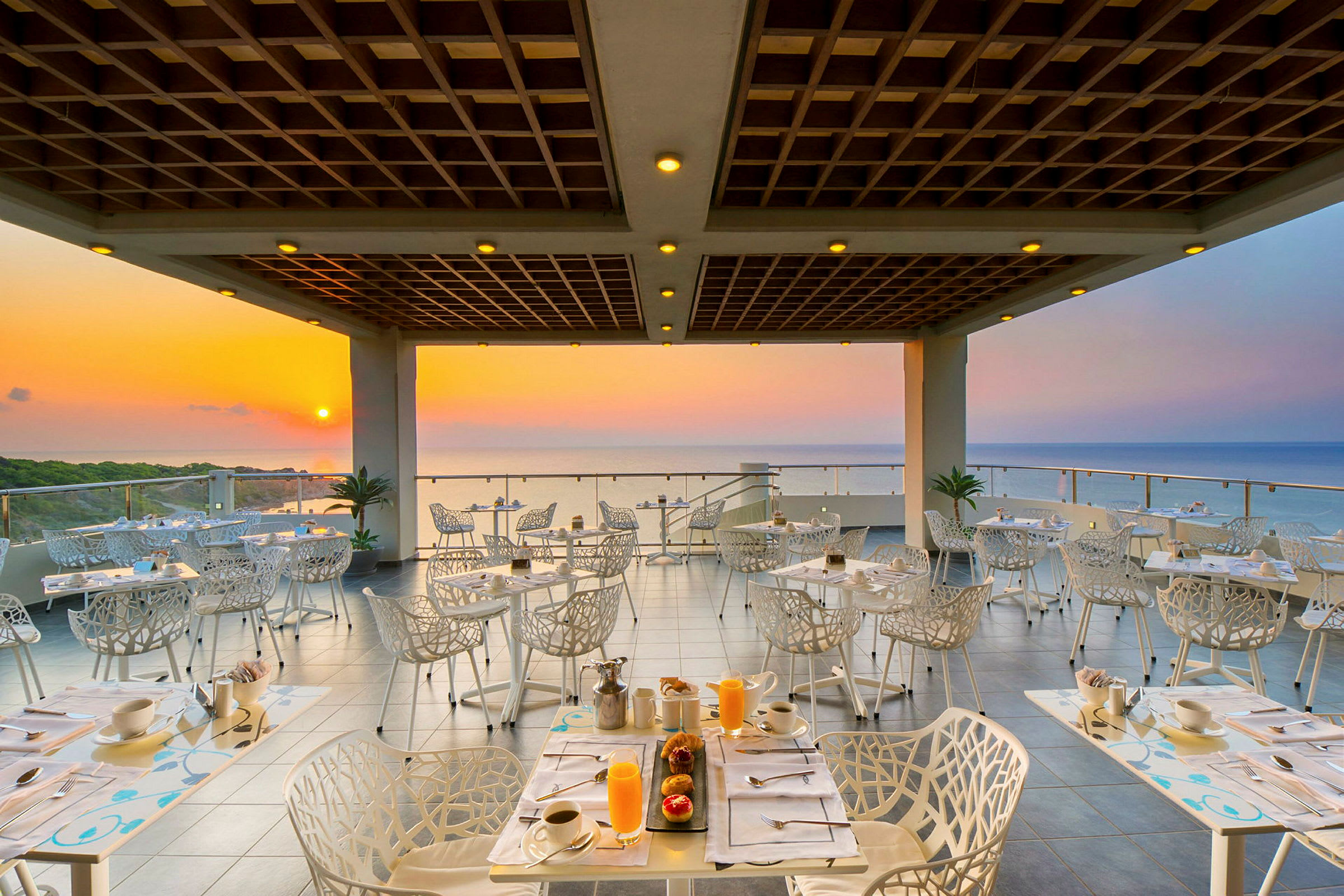 En restaurant med utsikt mot havet ved solnedgang. (AI-generert tekst)