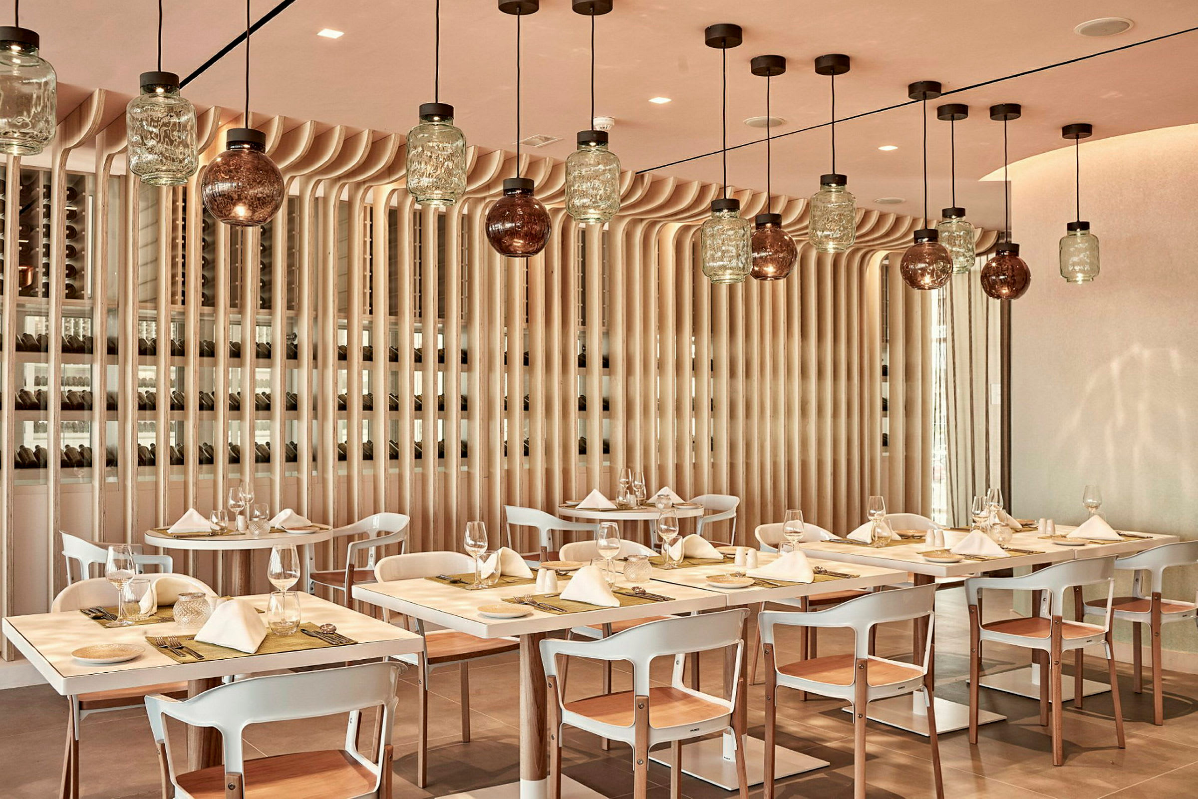 En restaurantinteriør med dekkede bord og moderne hengende lamper. (AI-generert tekst)