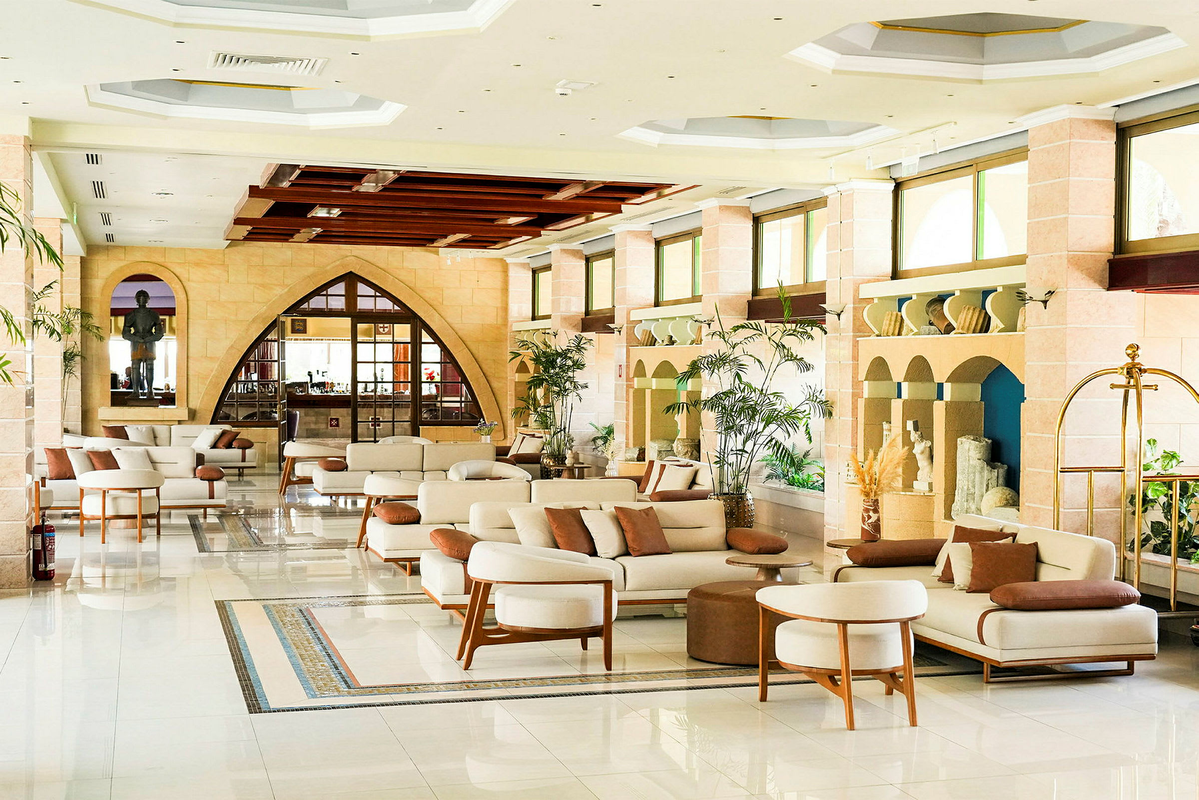 En elegant lobby med moderne møbler, planter og store vinduer. (AI-generert tekst)